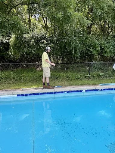 Technician using a hydrophone listening device to locate a leak in a commercial swimming pool in Zelienople Pennsylvania