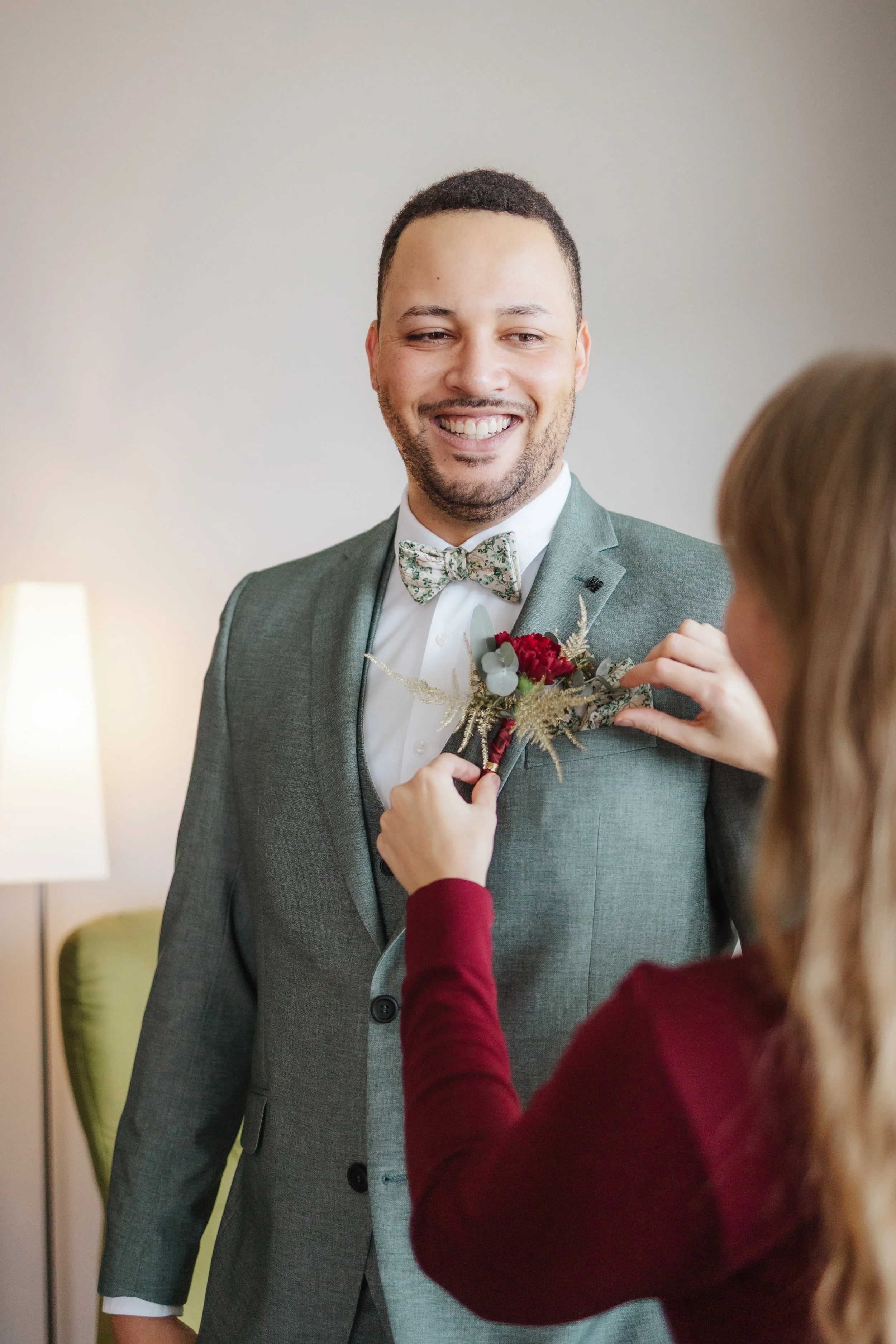 Hochzeitsplanerin beim Vorbereiten des Bräutigams am Hochzeitstag