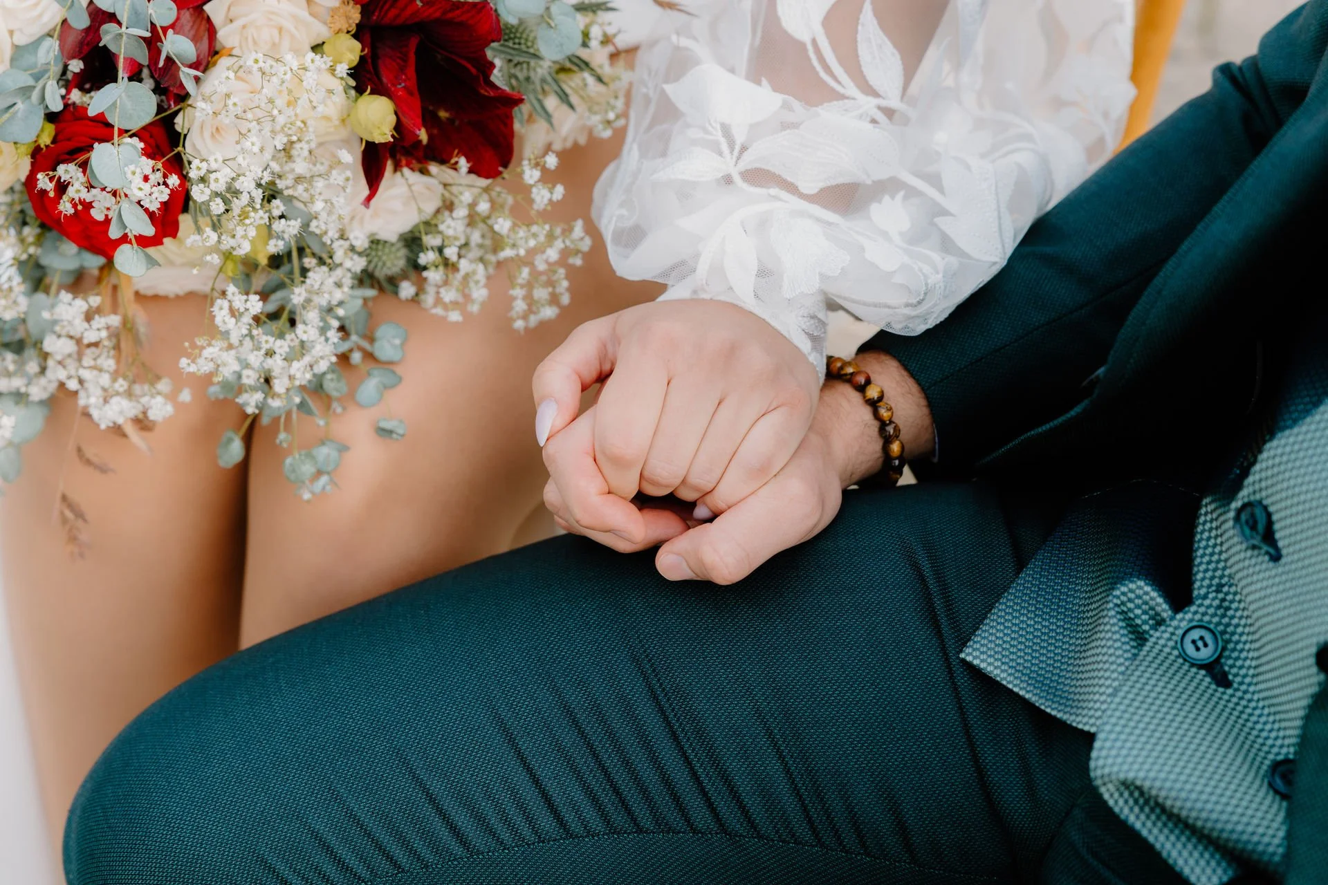 Ein Brautpaar hält sich bei der Trauung an den Händen.
