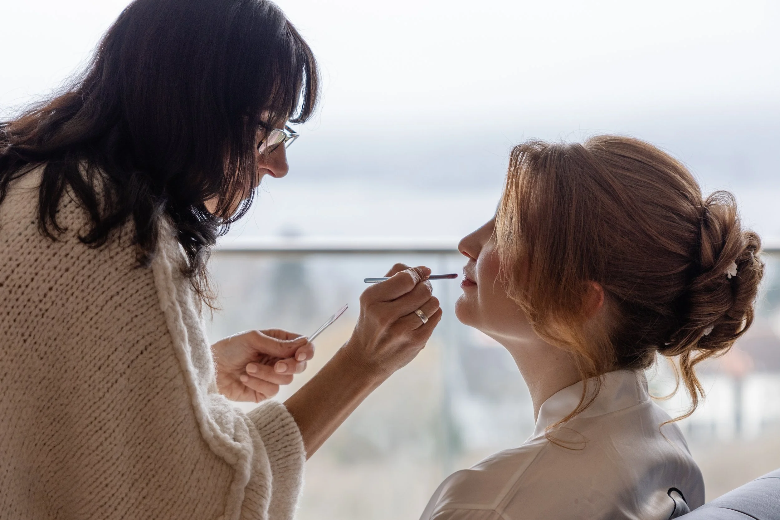 Vorbereitung der Braut bei Styling und Make-Up am Hochzeitstag