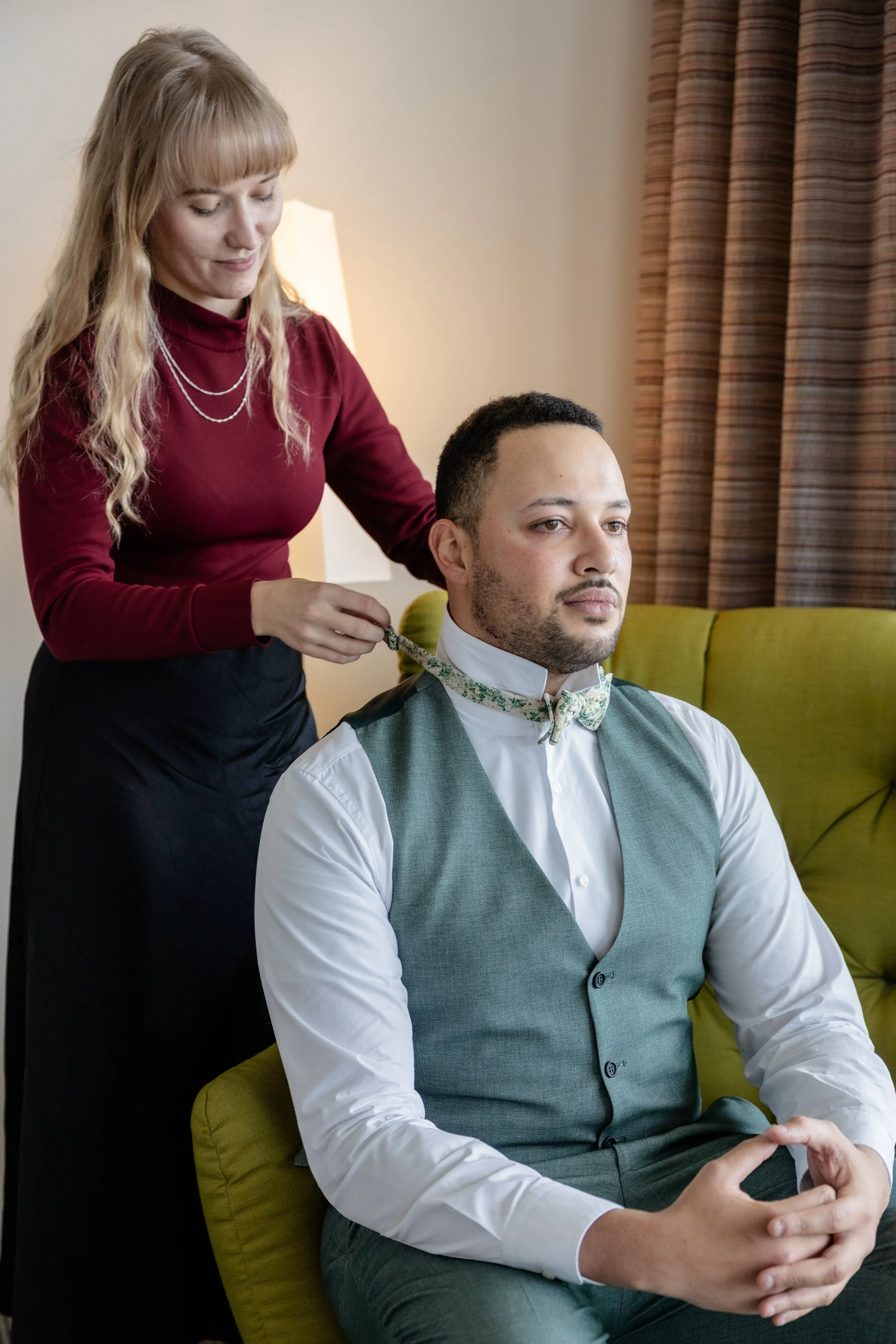 Hochzeitsplanerin beim Vorbereiten des Bräutigams am Hochzeitstag