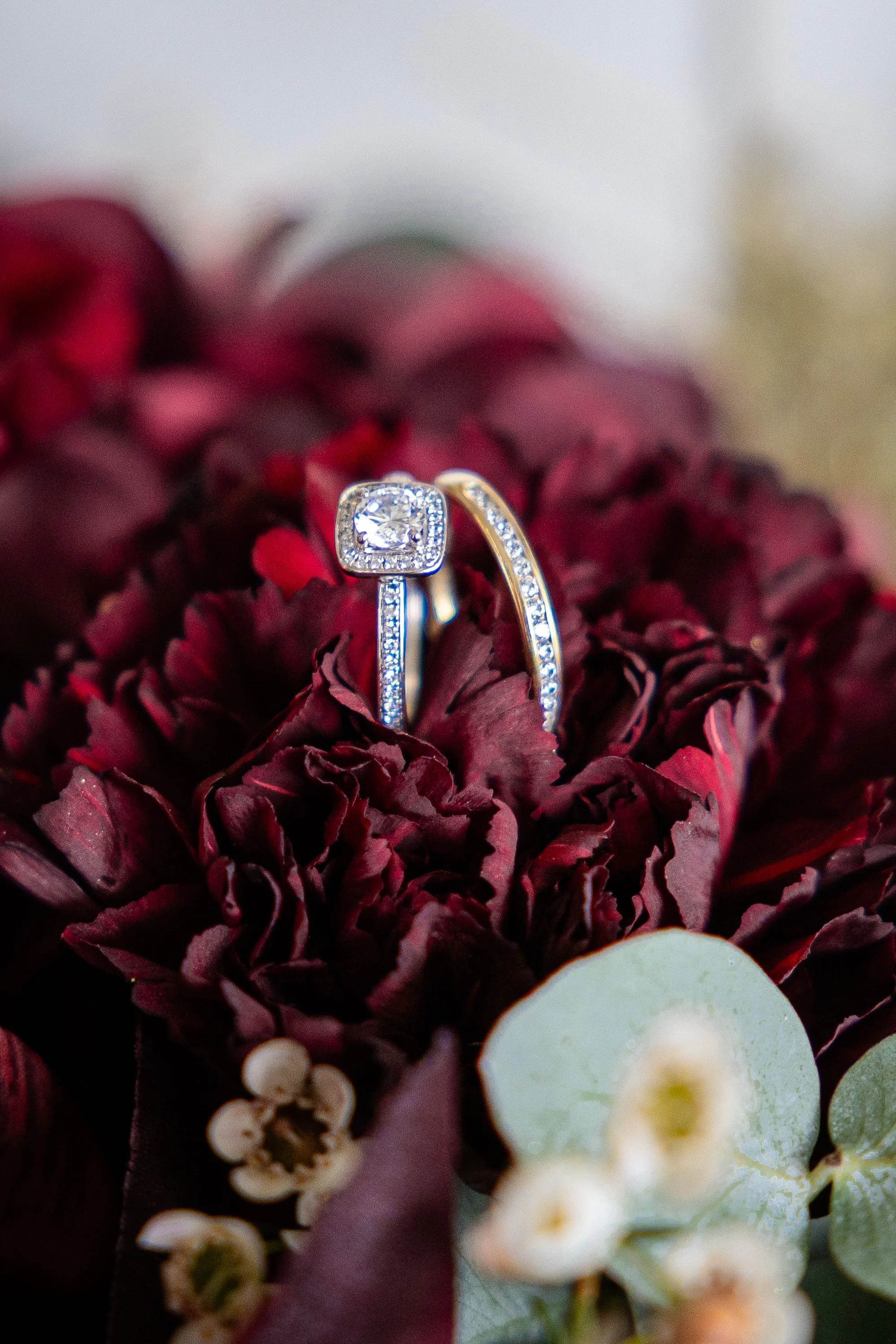 Verlobungsring mit Diamant auf roten Blumen