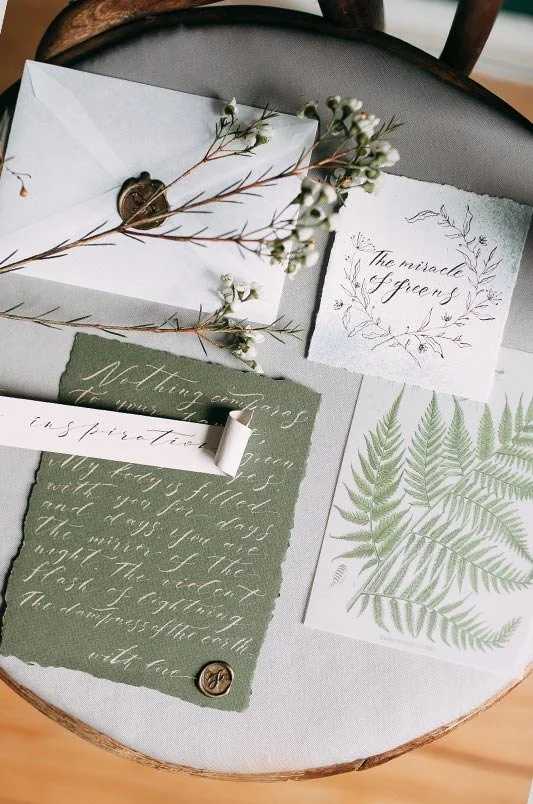 Stilvolle grüne Hochzeitspapeterie mit botanischem Design, Wachssiegel und Blätterzweig – liebevolle Hochzeitsdetails mit Naturbezug für eure Planung in der Schweiz.