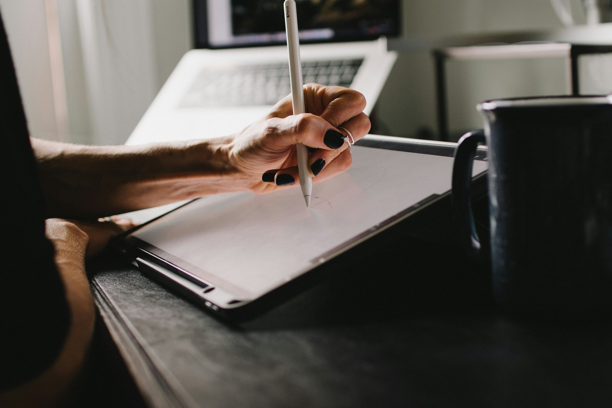 Hochzeitsplanerin entwirft kreative Ideen auf iPad am Schreibtisch – individuelle Hochzeitskonzepte digital gestaltet.