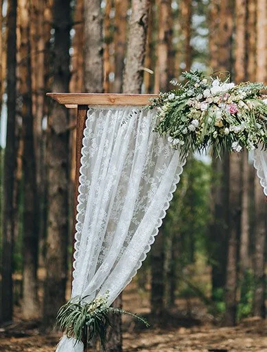 Vintage Hochzeitsdeko mit Spitzenvorhang im Wald – romantische Outdoor-Trauung in der Ostschweiz.