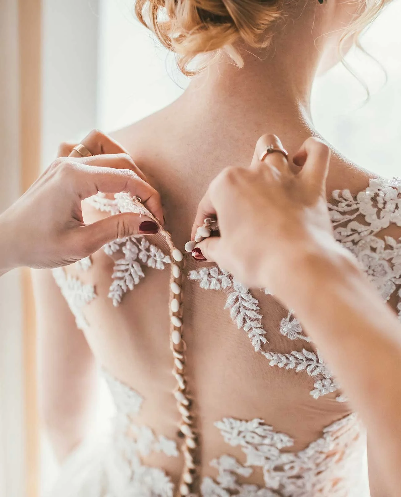 Intimer Getting-Ready-Moment – Braut wird in ein detailverliebtes Spitzenkleid gehüllt, emotionaler Augenblick vor der Hochzeit.