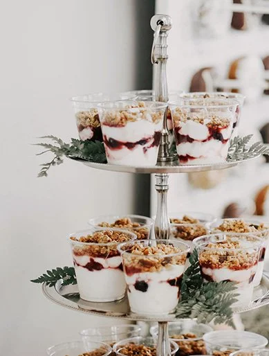 Stilvolle Hochzeitsdesserts im Glas mit Beeren und Joghurt, liebevoll angerichtet auf Etagere – Sweet Table Inspiration für moderne Hochzeiten.