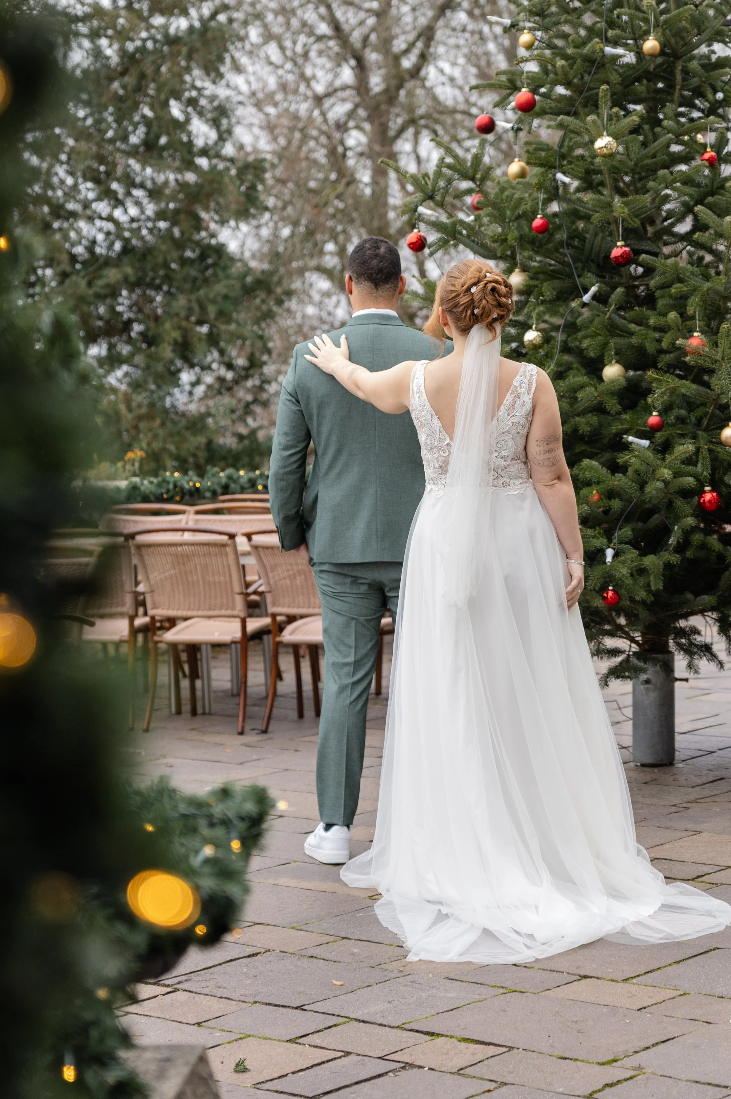Braut und Bräutigam kur vor einem First Look vor einem Weihnachtsbaum