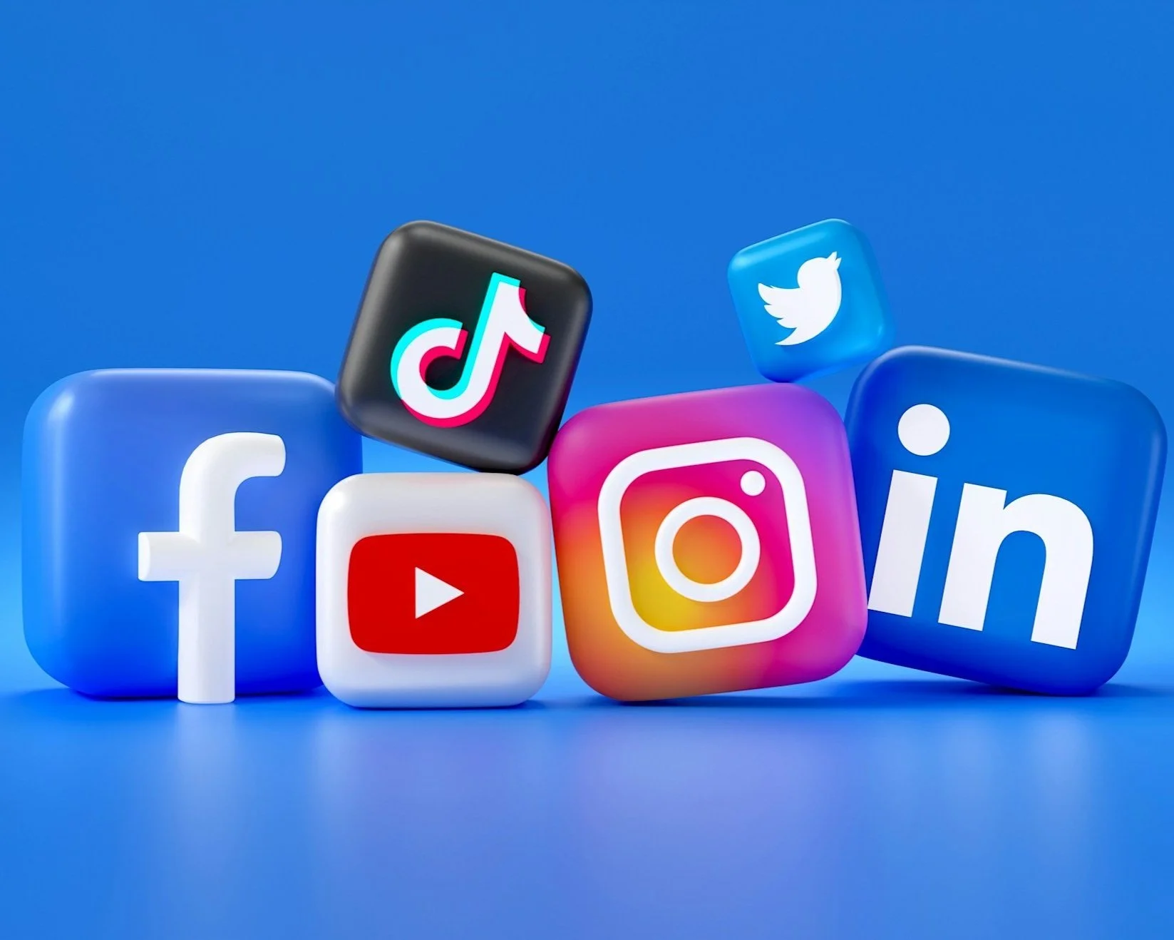 Various social media logos including Facebook, YouTube, TikTok, Instagram, Twitter, and LinkedIn displayed on 3D cubes against a blue background.