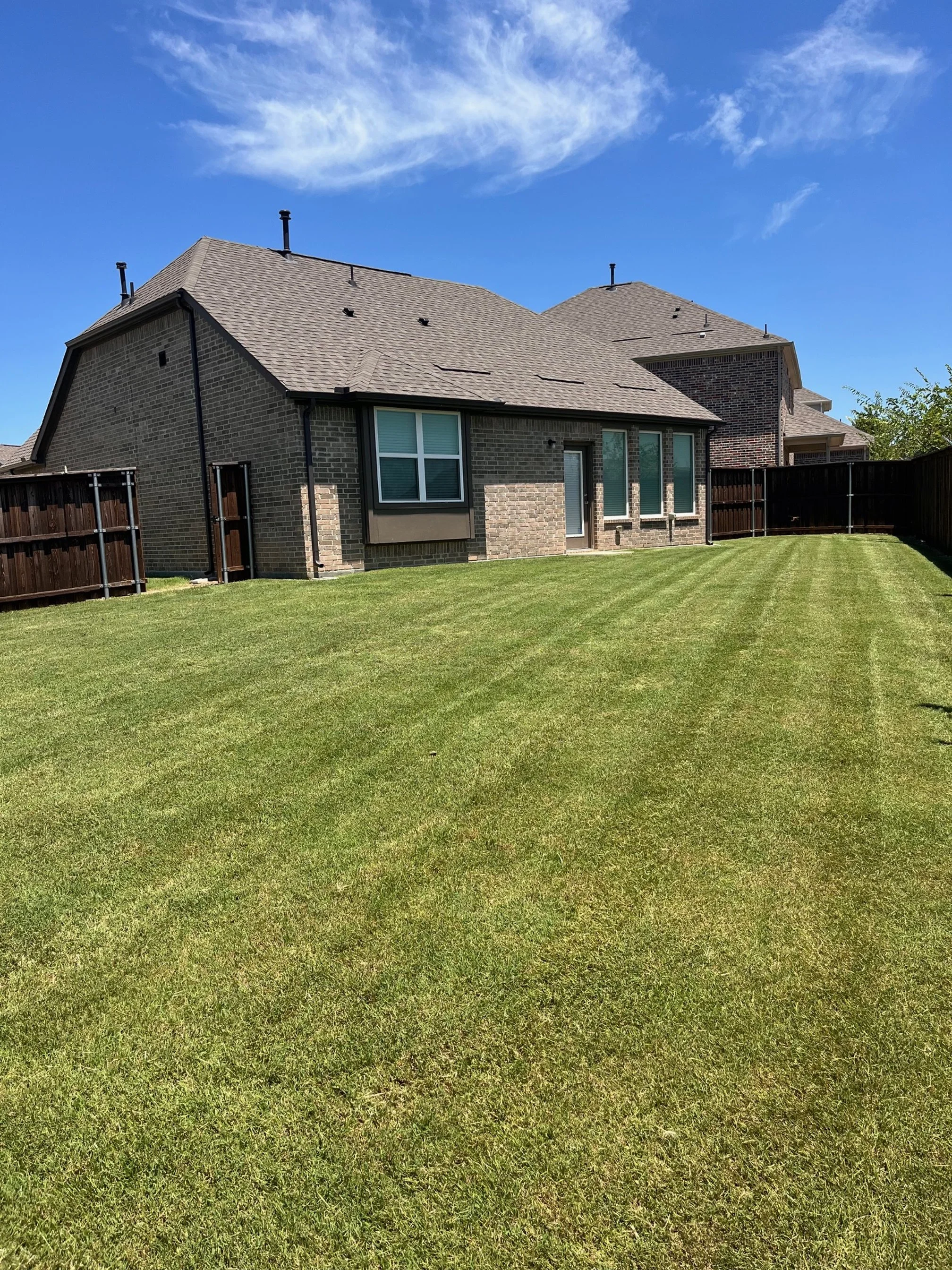 After photo of a fertilized residential lawn in Garland, TX showing thick, healthy, green turf.