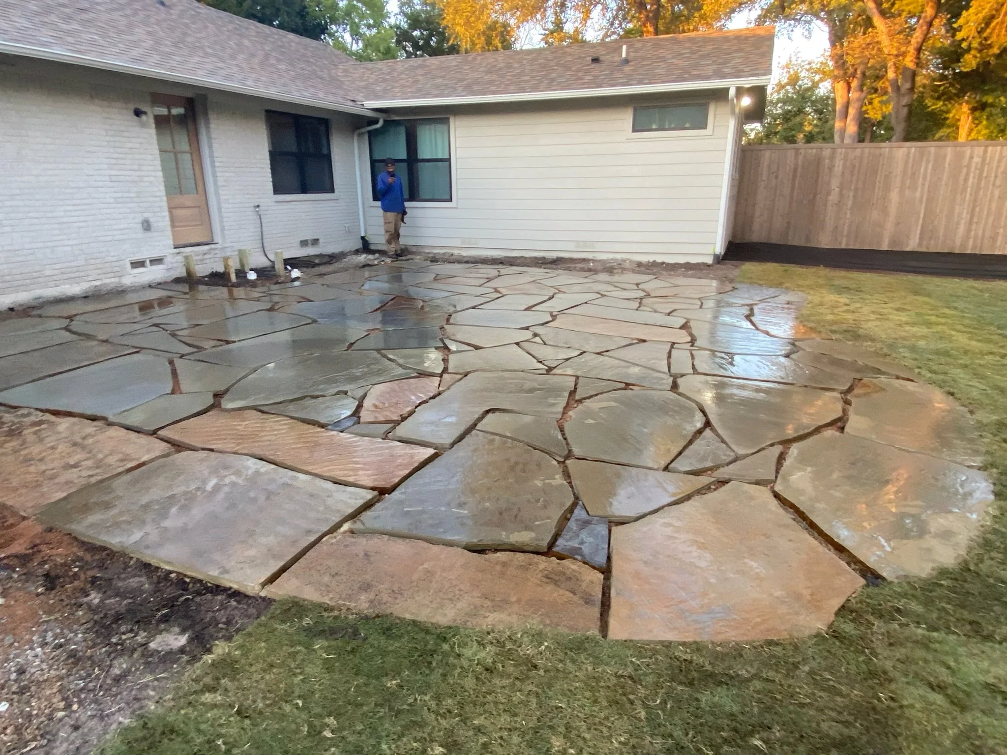 After: graded yard with new flagstone patio and garden bed enhancements in Dallas TX