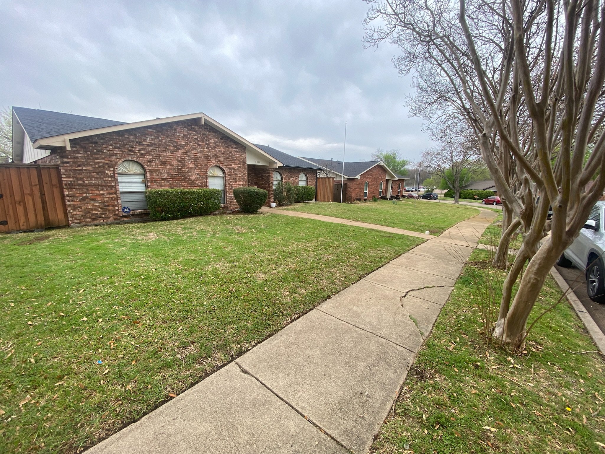 Before photo of a sparse, thin residential lawn in Garland, TX before spring overseeding and fertilization.