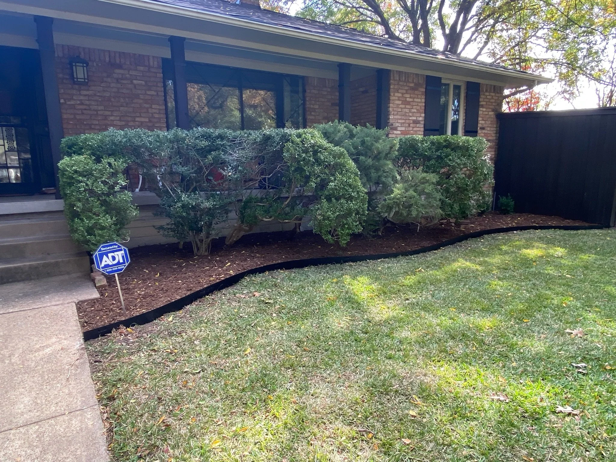 After photo showing reshaped garden bed with new steel edging and fresh mulch in Mesquite, TX.
