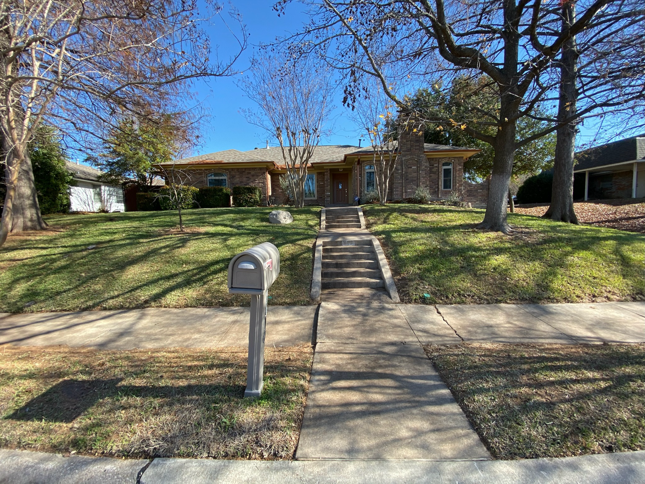 After photo showing a leaf-free, clean residential lawn in Garland, TX after fall leaf cleanup service.
