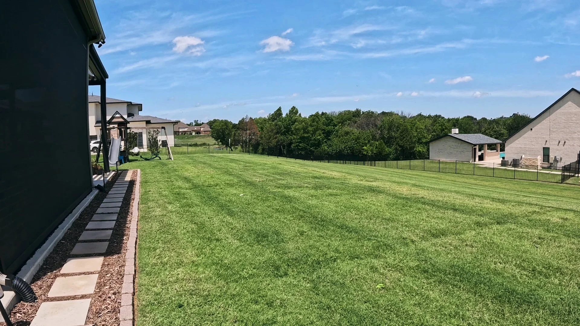 After photo of a Sunnyvale, TX lawn after top dressing, overseeding, and fertilization showing thicker, greener turf.