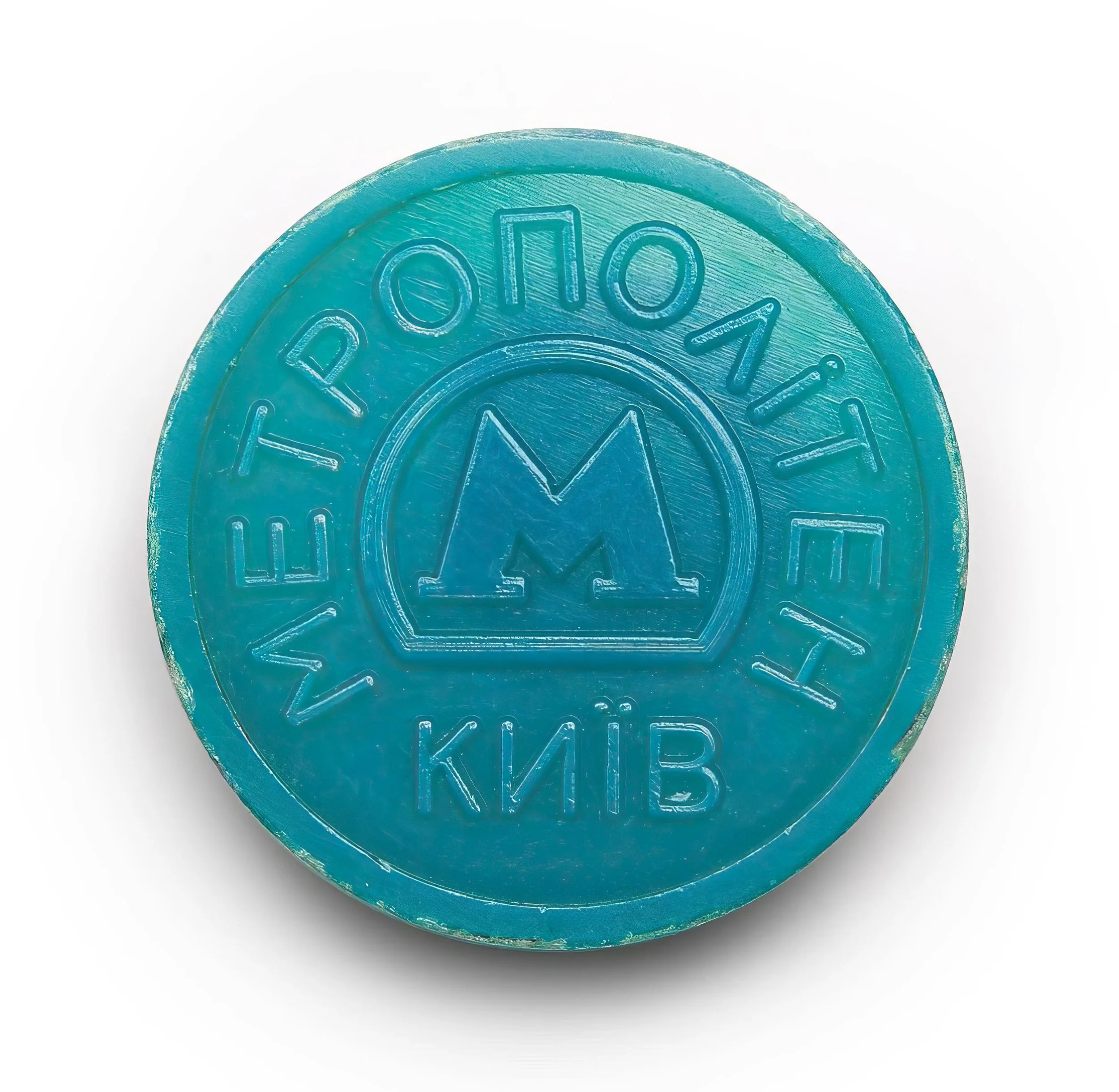 A blue circular token with the emblem of the Kyiv Metro, featuring a stylized letter 'M' in the center, and the words 'МЕТРО КИЇВ' (Kyiv Metro) in Cyrillic around the edge.