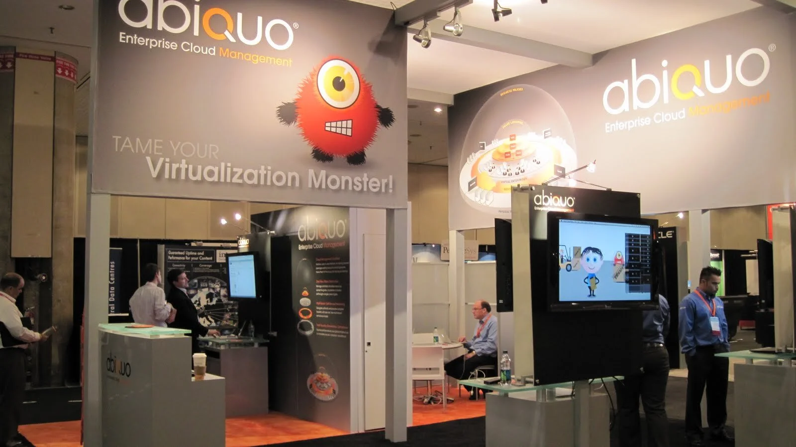 Trade show booth for abiquo Enterprise Cloud Management with banners, monitors displaying graphics, and people attending.