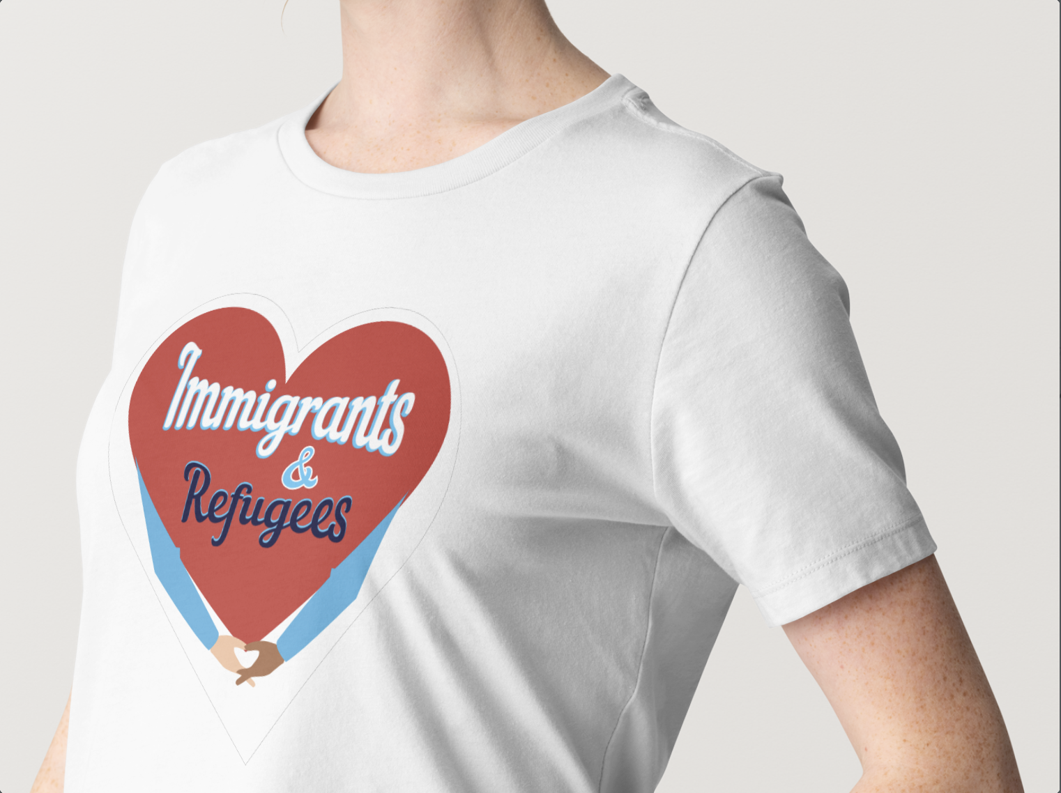 Person wearing a white t-shirt with a graphic of a heart and hands, with the text 'Immigrants & Refugees' inside.