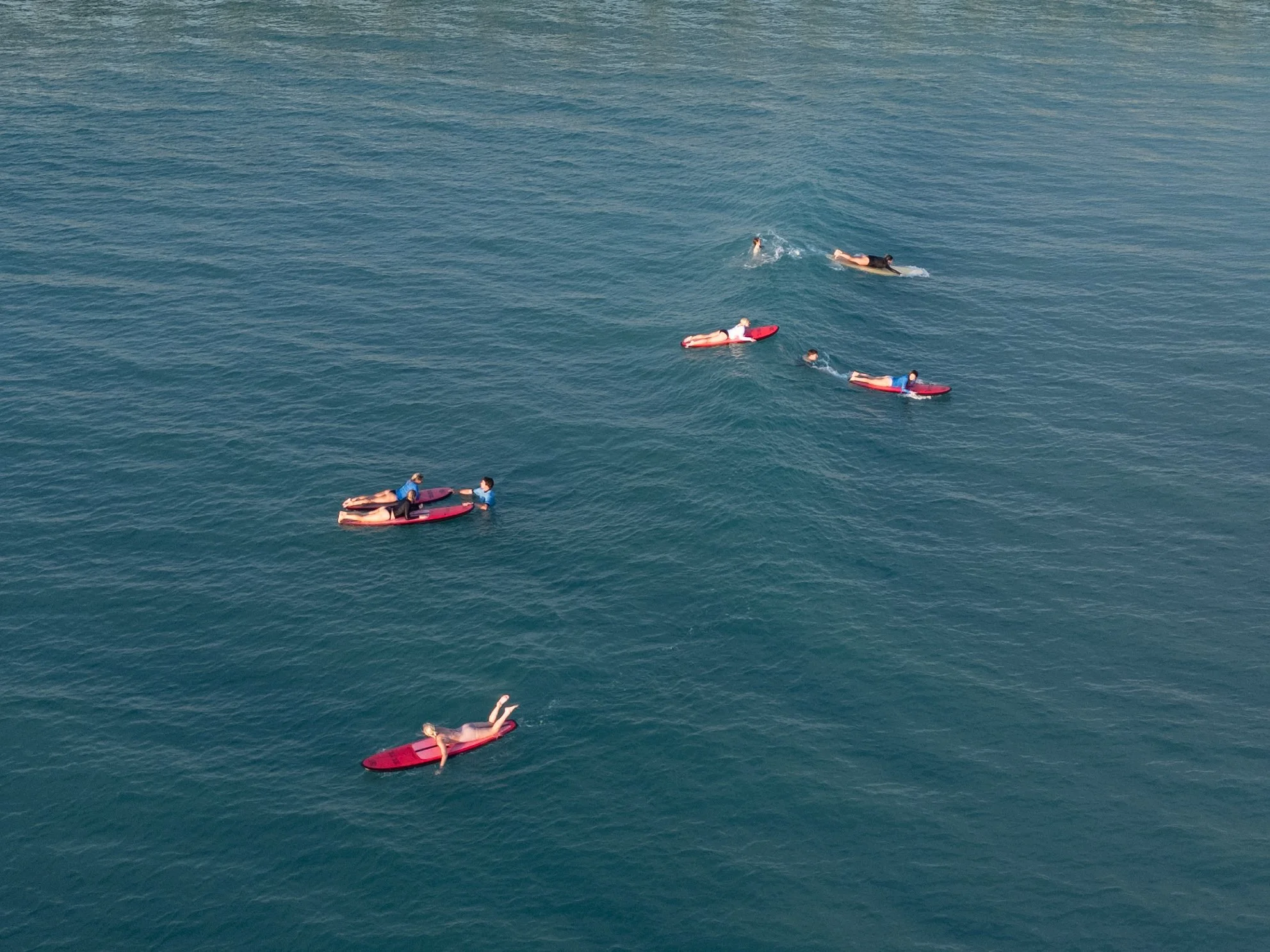 Six people on paddleboards floating on calm water.