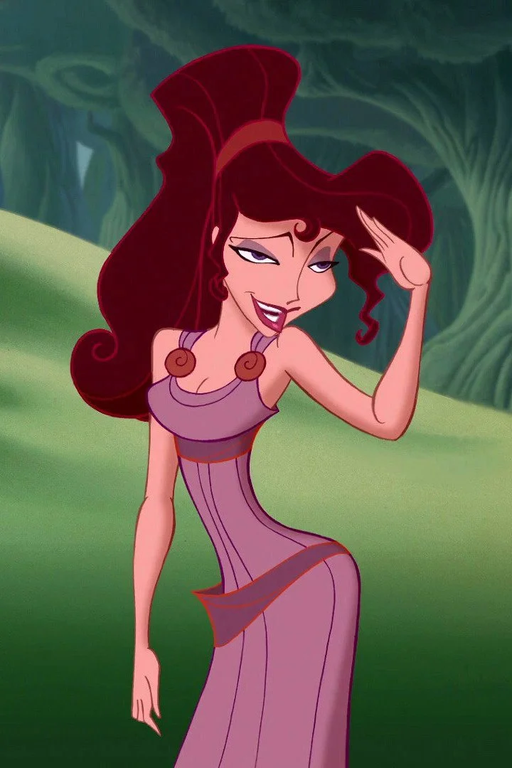 A woman with long red hair wearing a purple dress with circular embellishments, standing outdoors in a green, forested area, saluting with a sly smile.