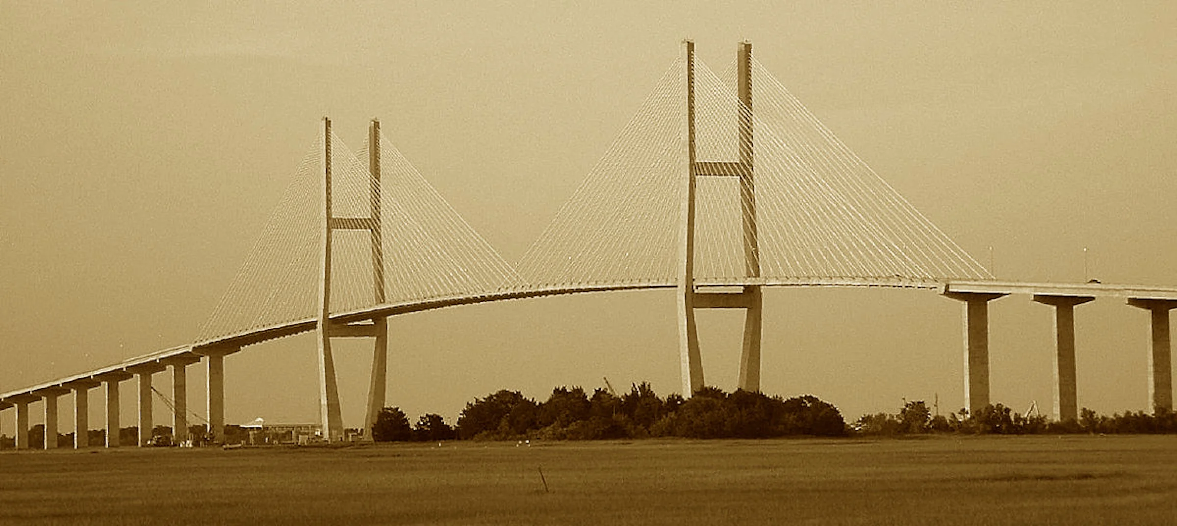 A poet’s name, a span so wide,
That lifts above the ocean tide.
Its towers rise in graceful might,
To give the ships their seaward flight.
Where cables stretch and stories cross—
This bridge stands firm, through fog and gloss.