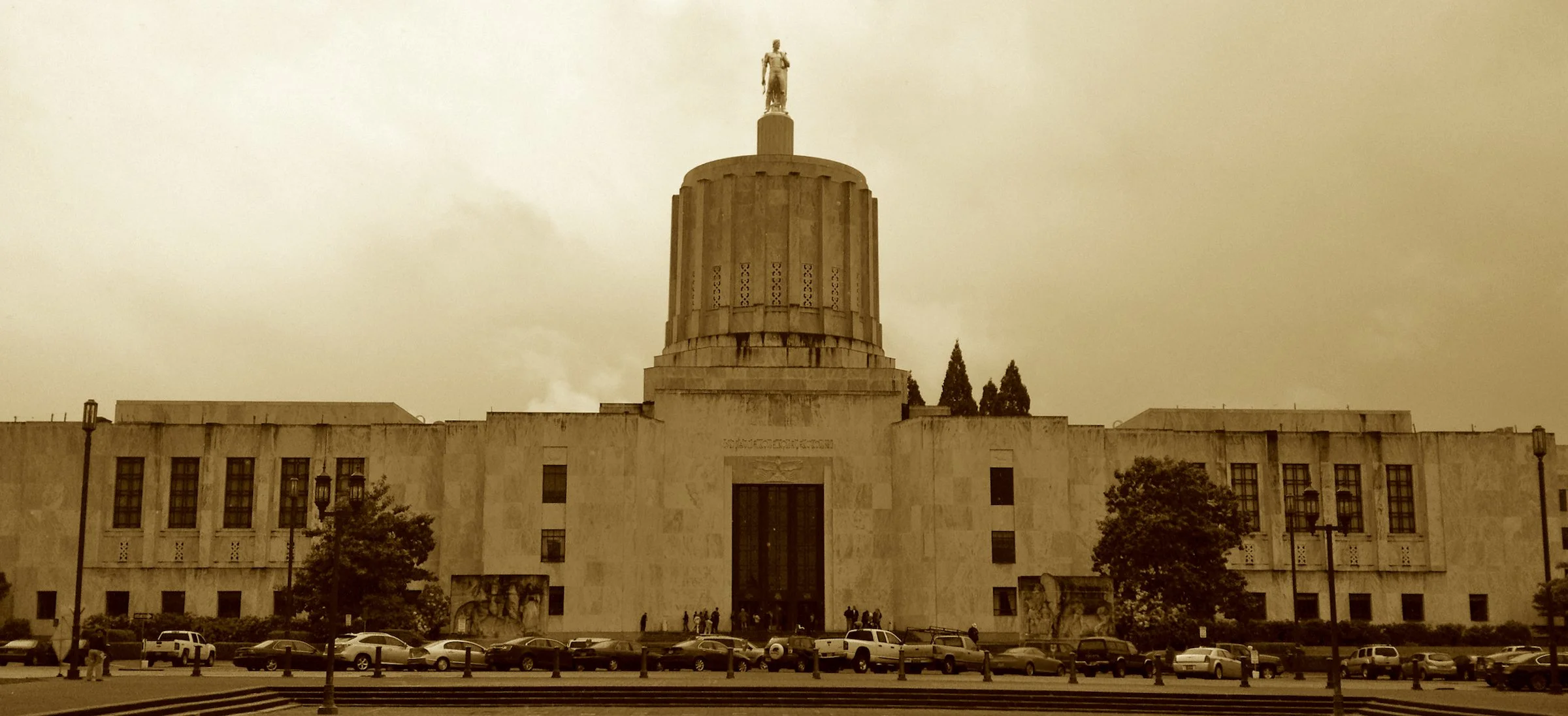 With marble from Vermont and a golden-crowned dome,
The Oregon Pioneer guards liberty’s home.
Three statehouses burned, but this one stands tall,
With murals that tell of the fur trapper’s call.
From fire to function, with Art Deco grace—
It shines l