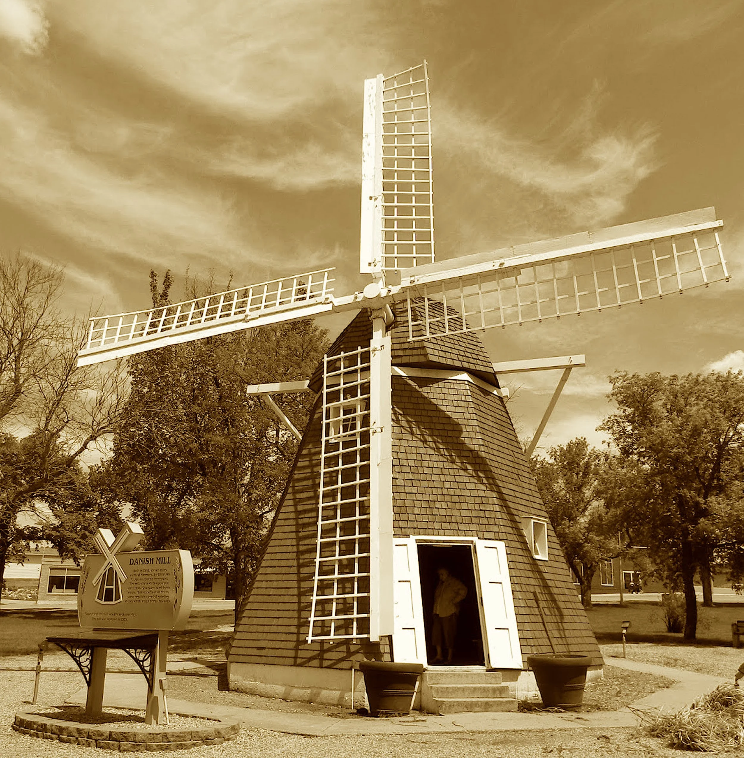 No Dutchman here, just Danish might,
Who built a mill to grind things right.
With canvas sails and gears hand-hewn,
It sang to grain a milling tune.
Now in the square, its blades don’t turn—
But still they catch the townsfolk’s yearn.