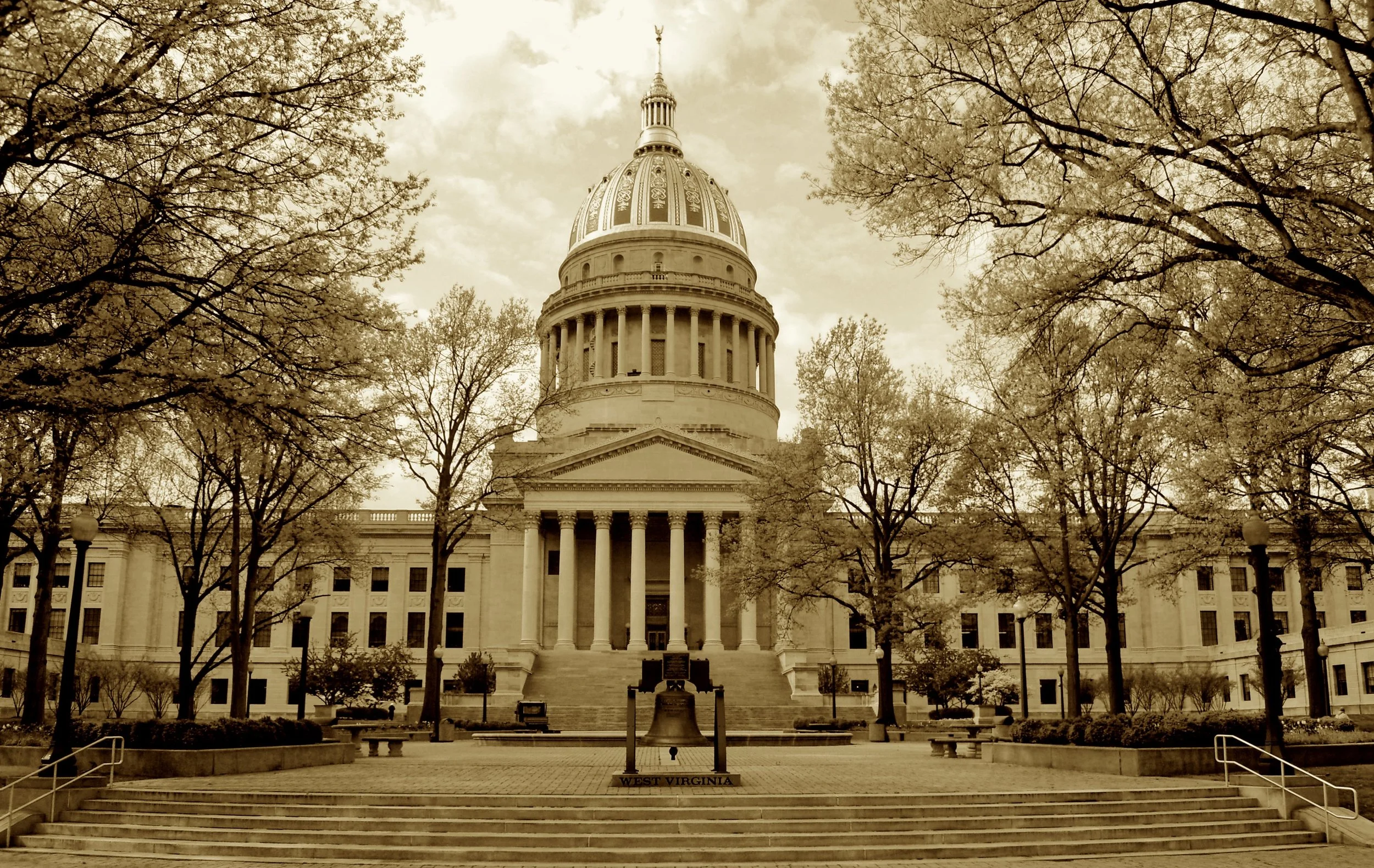 A golden dome in marble bright,
Crowned Charleston with its stately height.
Three phases shaped its towering pride,
With limestone wings on either side.
Cass Gilbert’s dome of gold and gleam—
The mountaintop of civic dream.