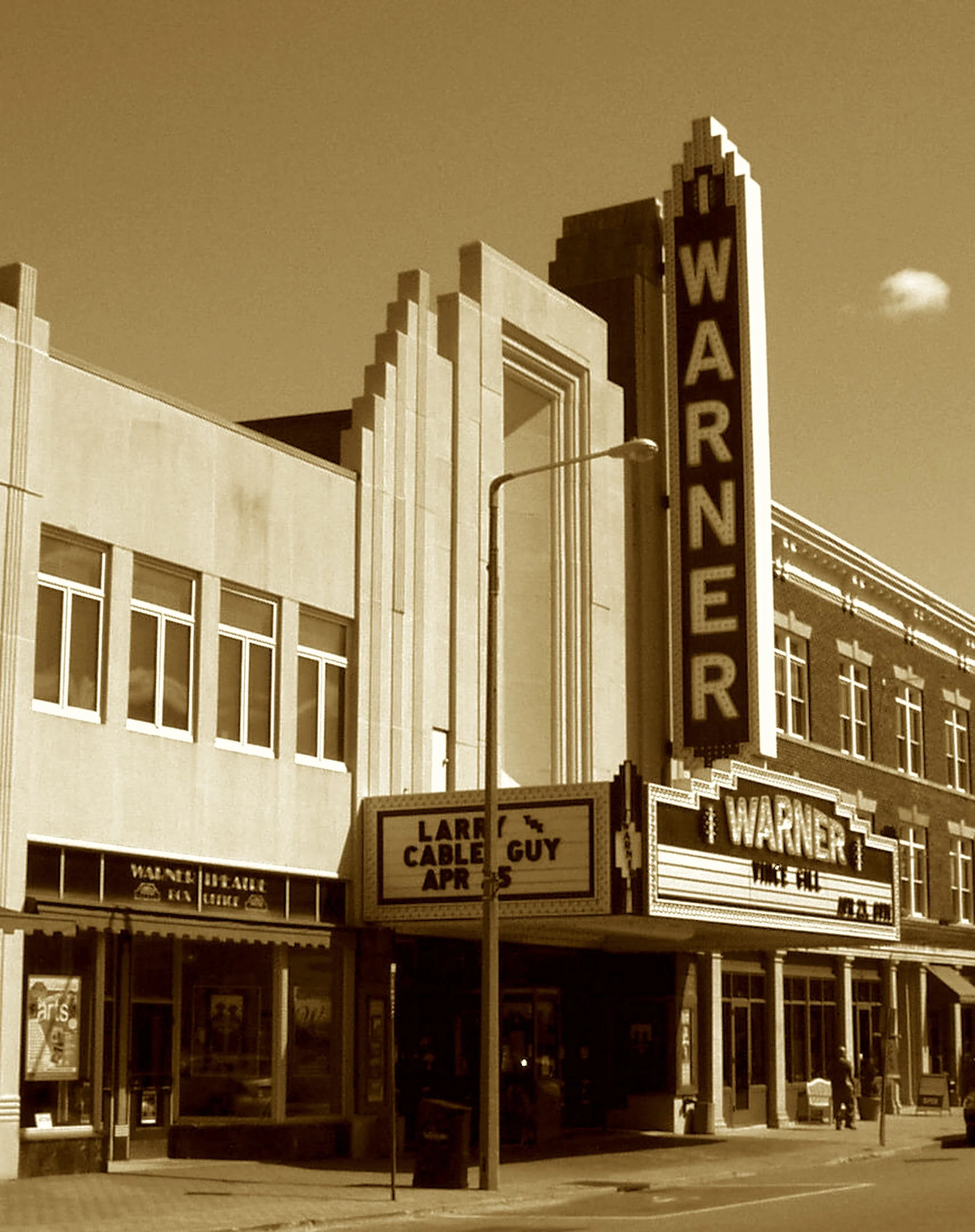 With Deco flash and chandelier,
The movies found a palace here.
The Warners crowned this showplace tall,
To test their films before they’d sprawl.
It fell, then rose, from flood and fade—
A phoenix on the culture stage.