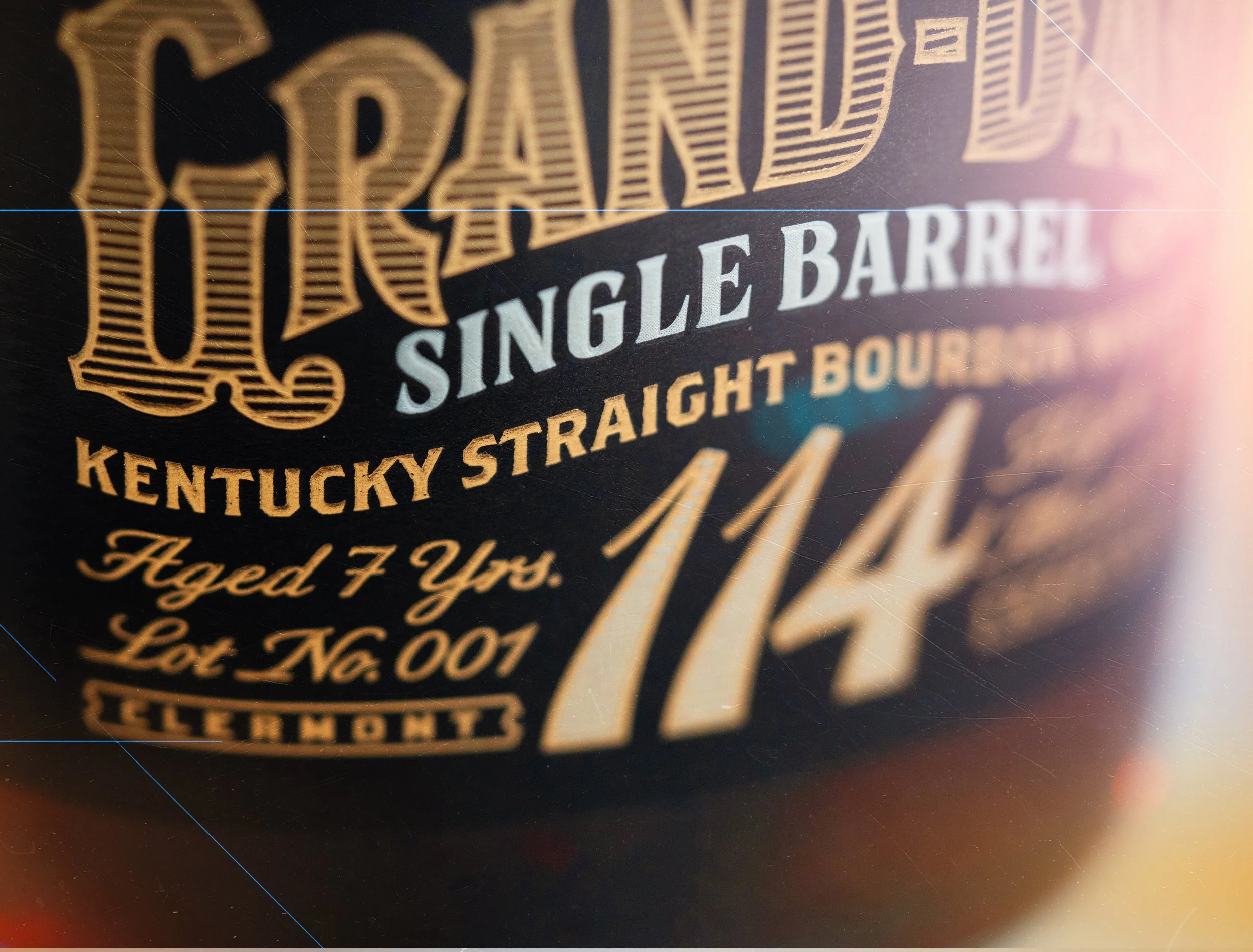 Close-up of a label with ornate design, gold and white text on a black background, mentioning 'Single Barrel Kentucky Straight Bourbon'.