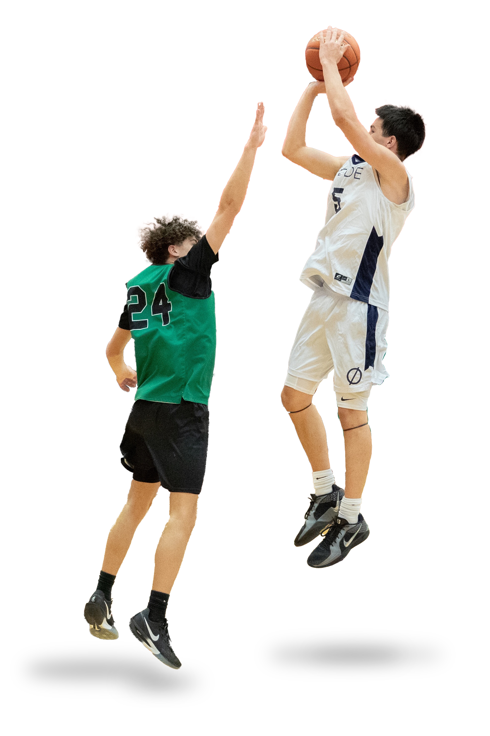 Two young male basketball players compete for the ball in mid-air, with one jumping to shoot or pass and the other jumping to block.