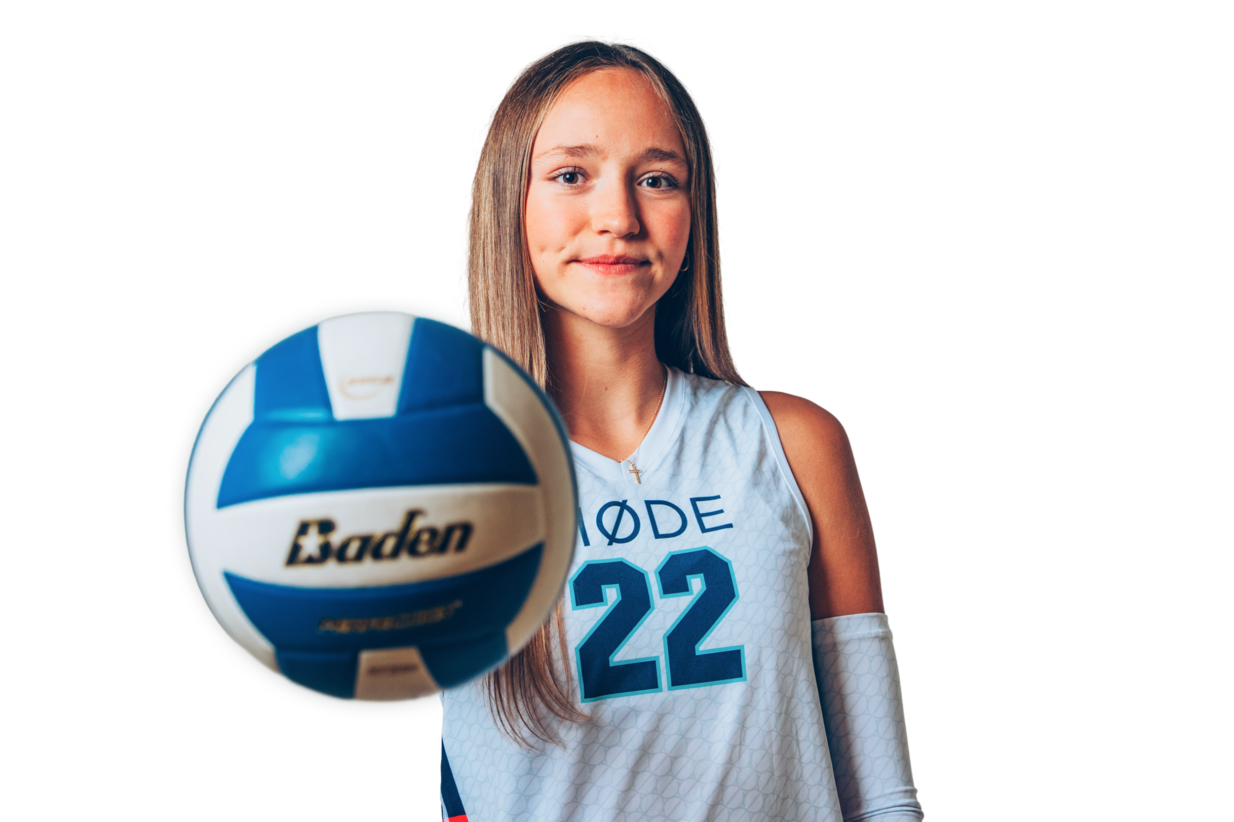A young female volleyball player with long blonde hair, wearing a white and blue volleyball jersey with the number 22, is holding a blue and white Baden volleyball towards the camera.