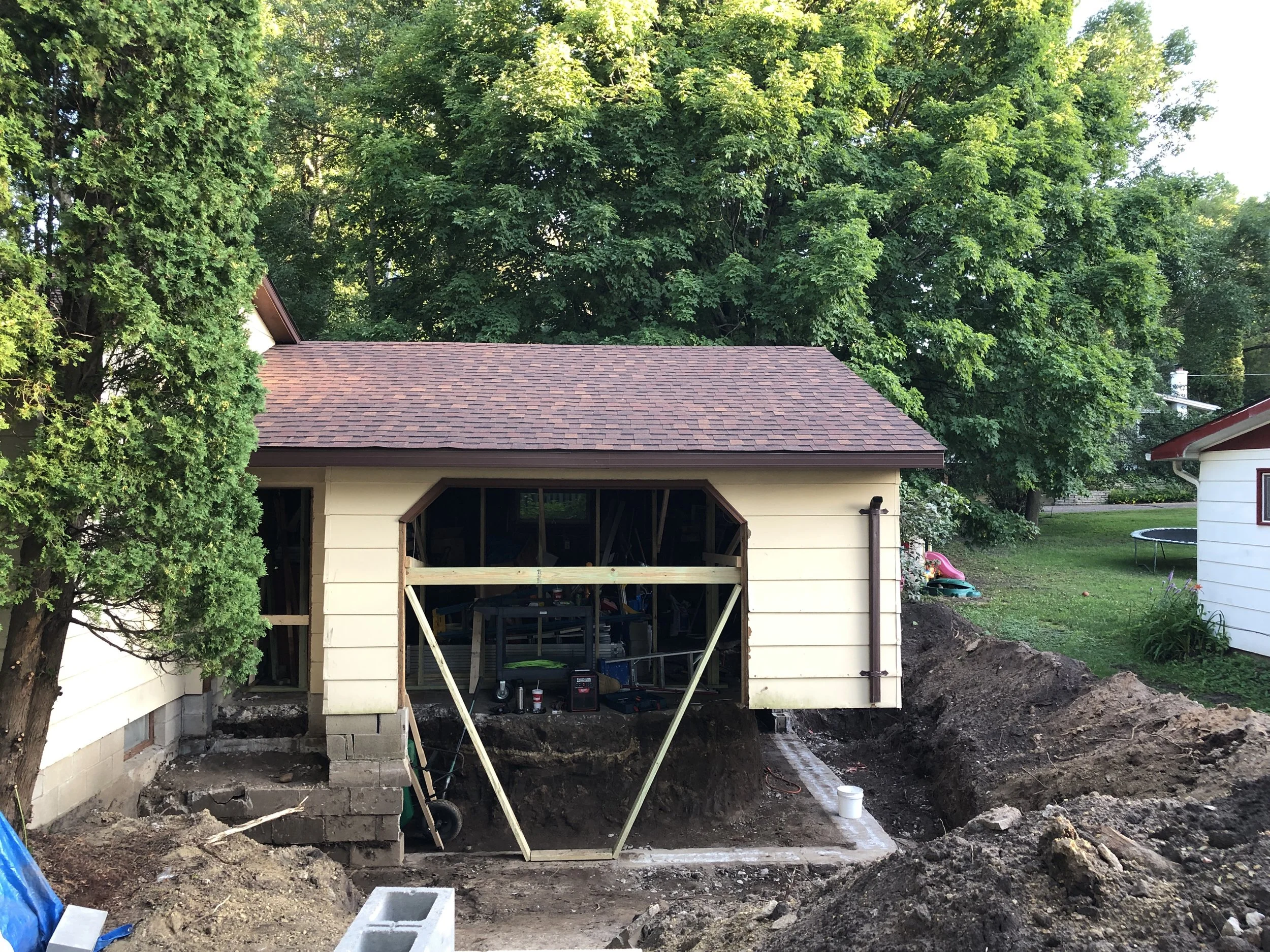 Construction site of a house with foundation work and exterior wall framing.