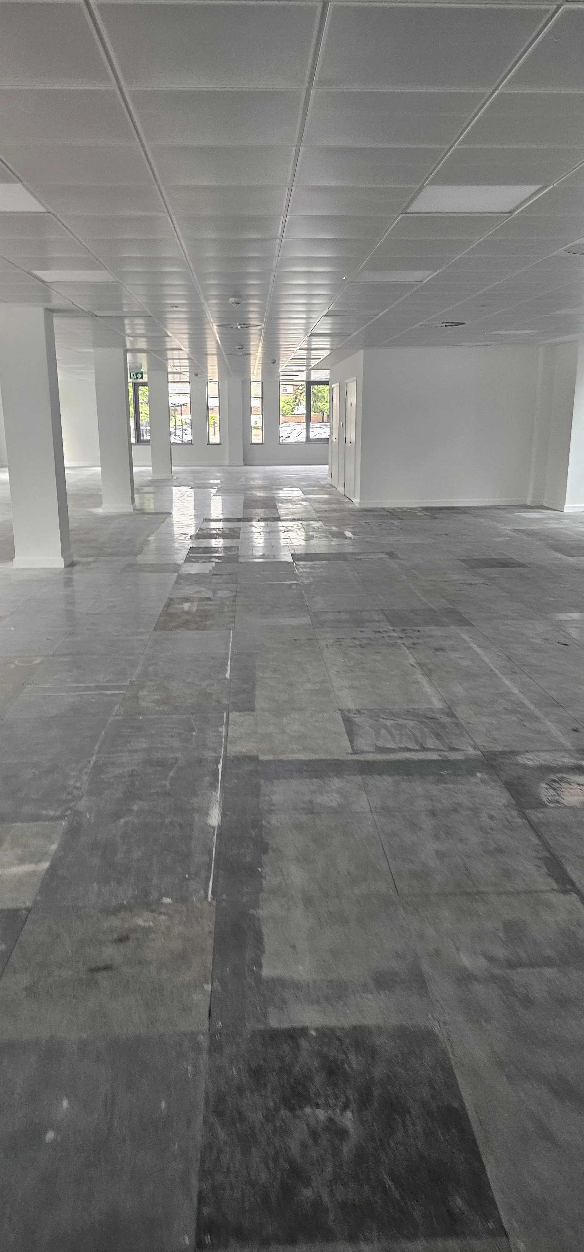 Cleaned raised access floor panels with adhesive and tackifier removed, ready for new flooring, Guildford office project