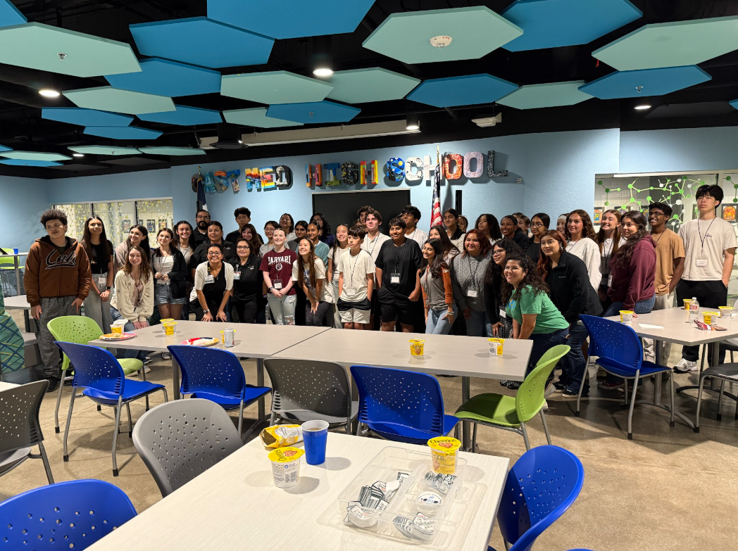 A large group of students in a school cafeteria posing for a photo in front of a wall that says 'Central High School'.