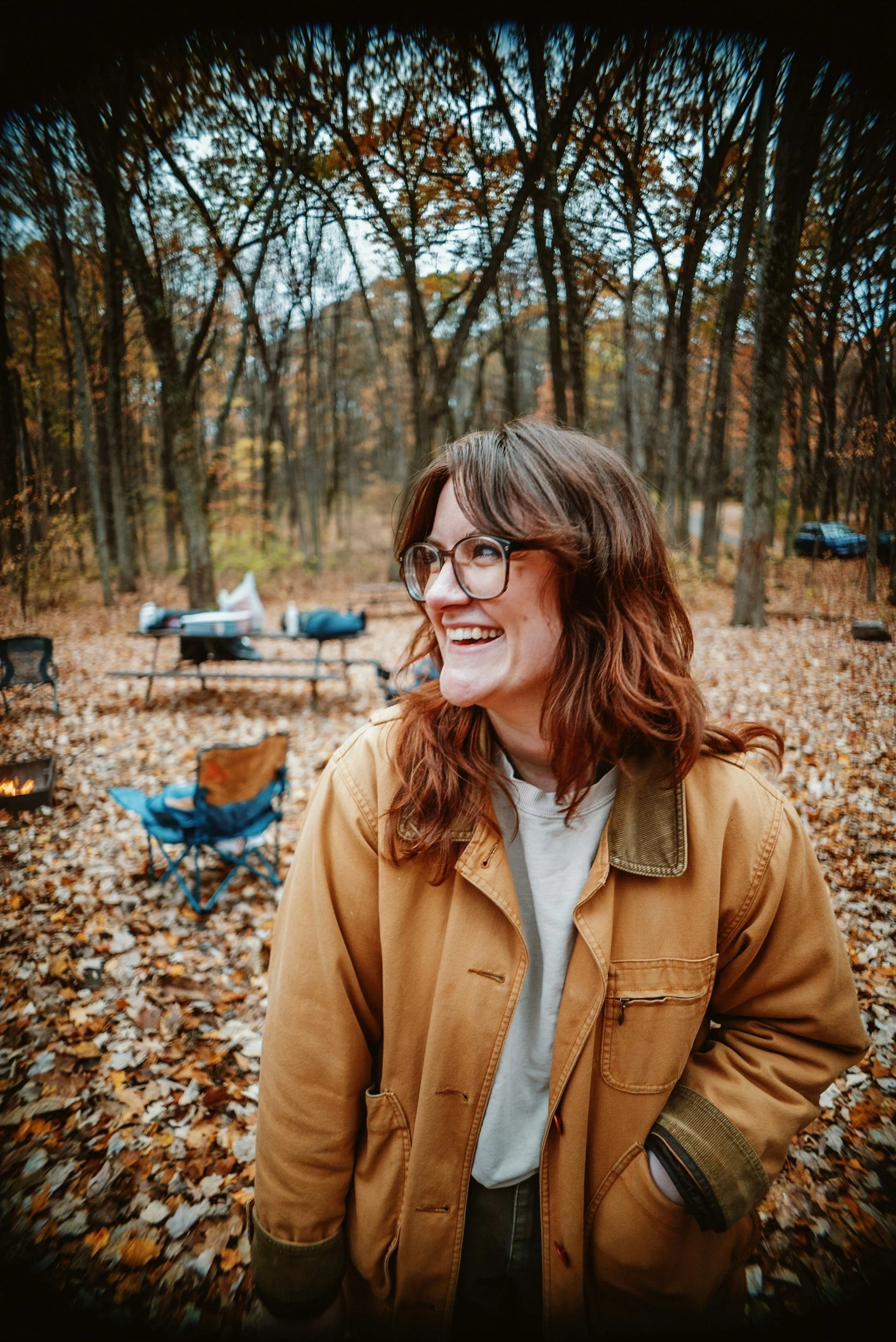 A woman smiles from a campsite in the great outdoors (on a dry day in the PNW) because she restarted her dental care with LifeSmile Dental Group