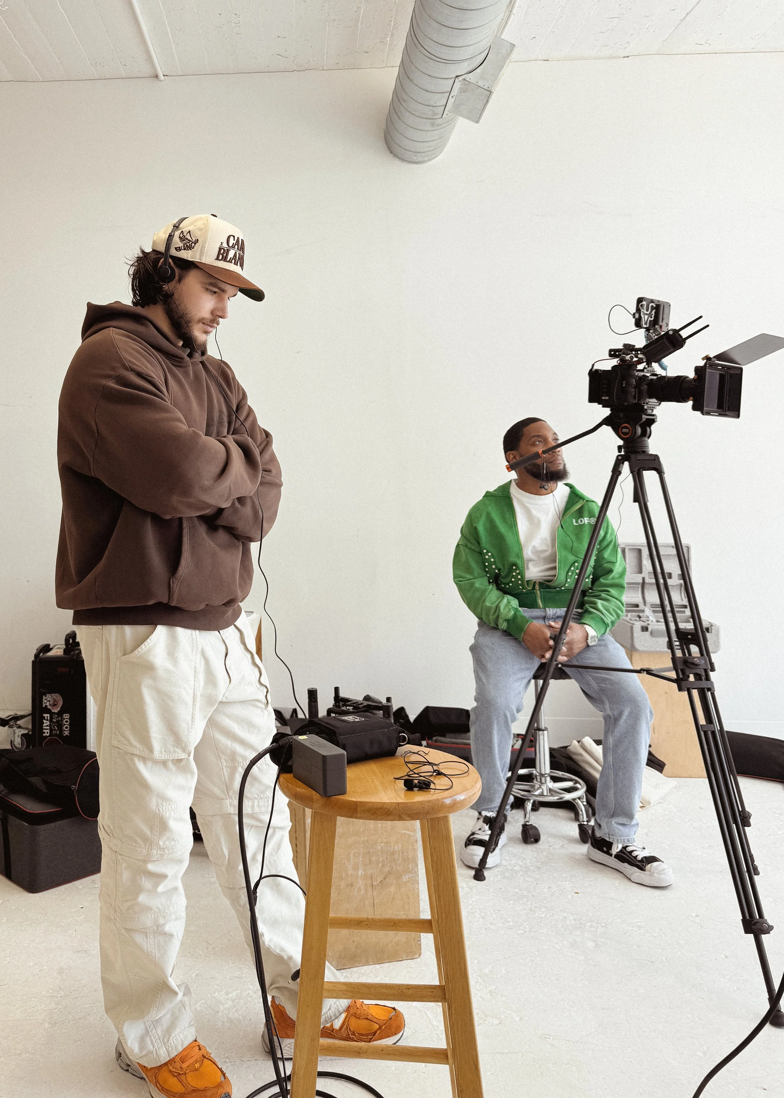 Behind-the-scenes of a video production in Atlanta, showing a videographer and subject preparing for a corporate video shoot in a studio setting.