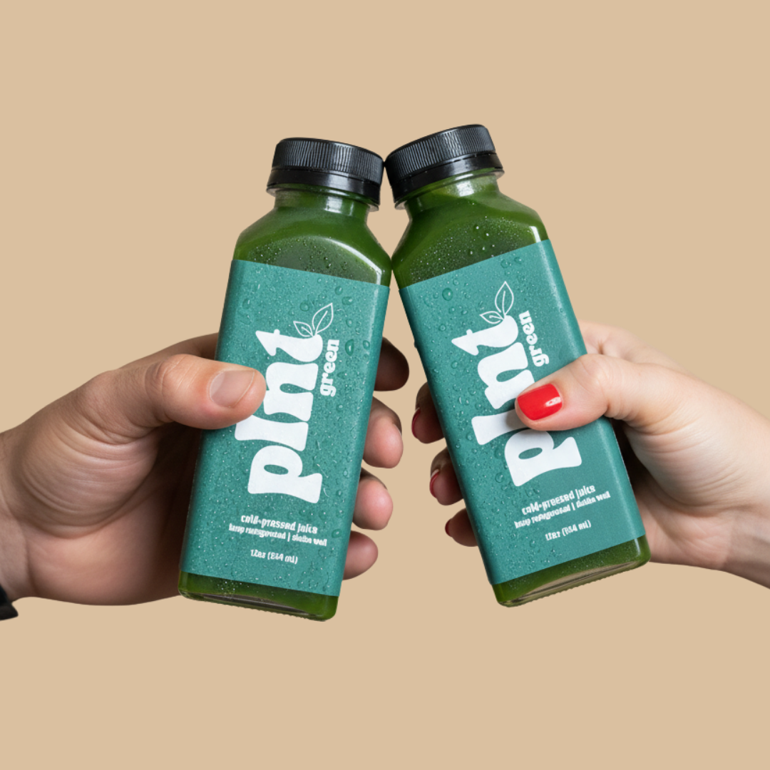 Two hands holding green bottles of Pixy green juice, clinking in a toast against a beige background.