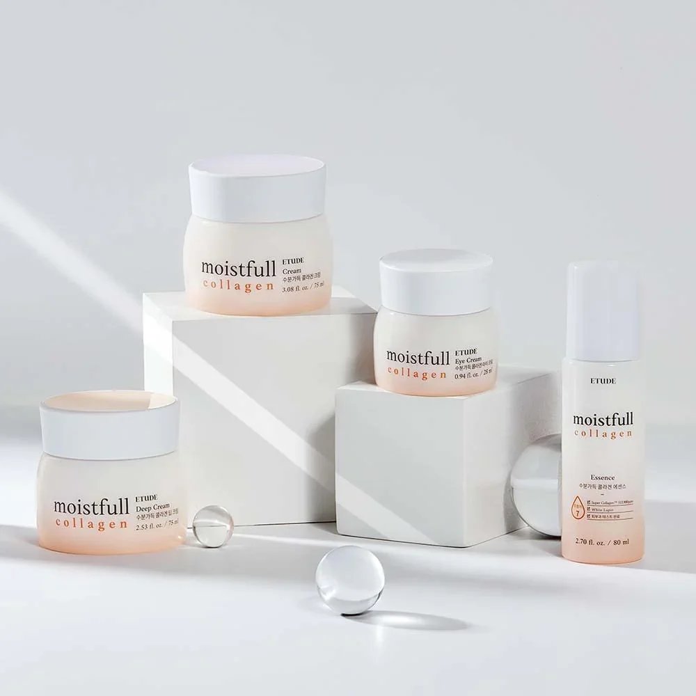Collection of ETUDE Moistfull Collagen skincare products including deep cream, eye cream, and essence on white surfaces with decorative glass or acrylic spheres.