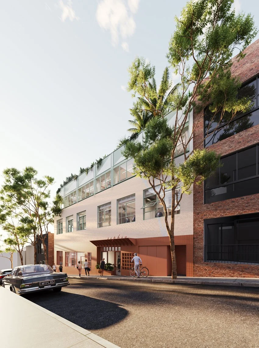 Modern multi-story building with trees in front, people walking and a man riding a bike on the sidewalk, a vintage black car parked on the street.
