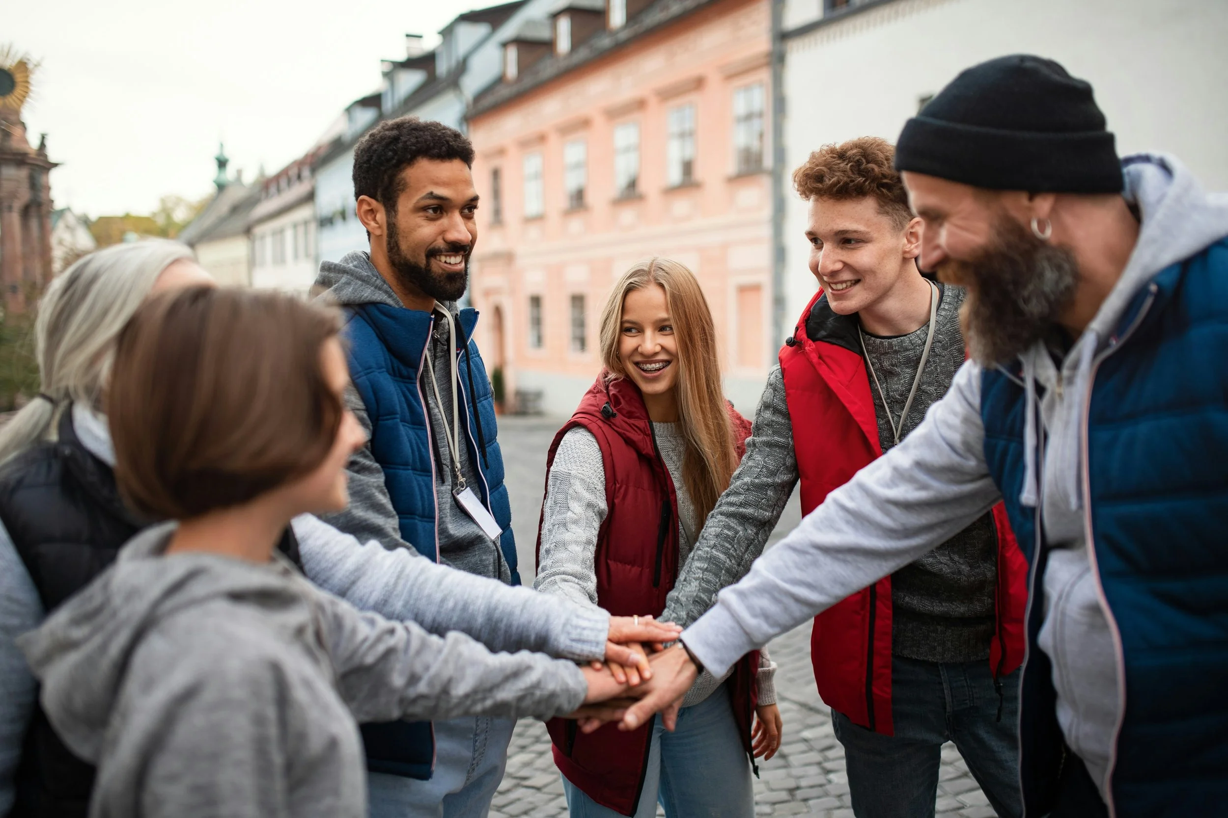 Group of people with hands together in the middle of a circle