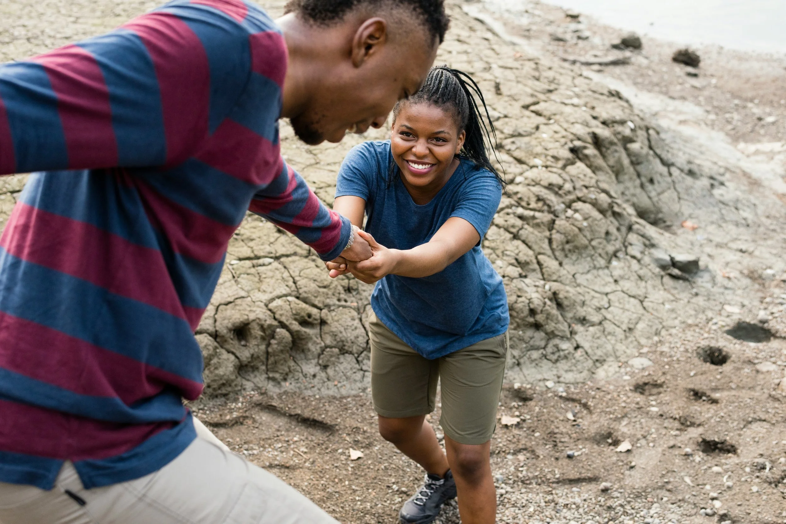 Young man helping young women up a hill