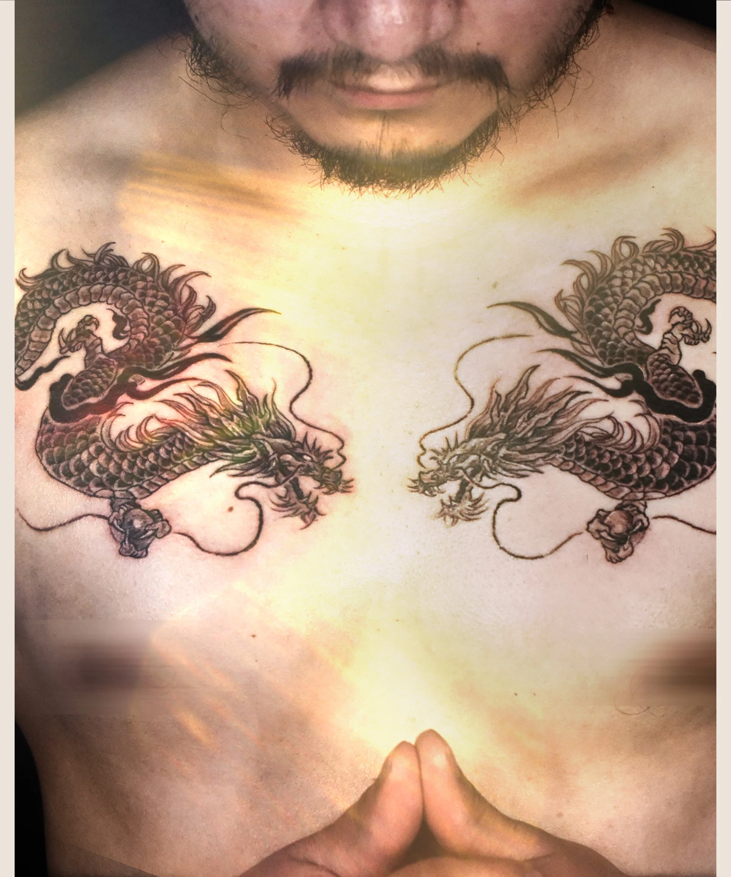 Two Black Dragons tattoo on chest facing each other , craft and designed by Bored ink club, located in Los Angeles