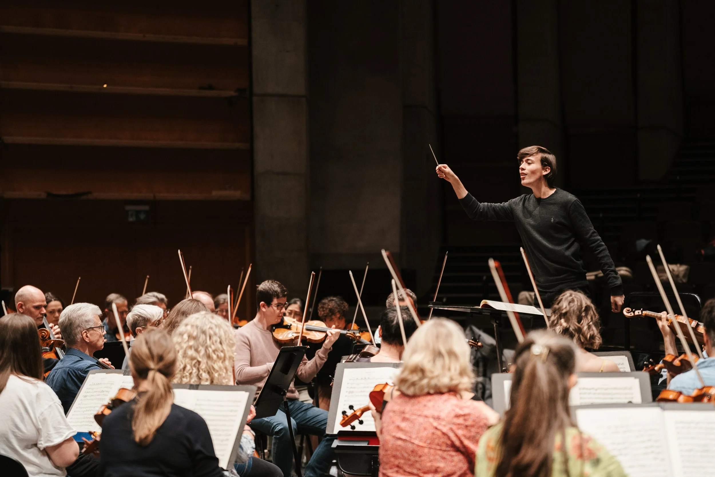 Orchestra performing with a conductor leading the musicians.