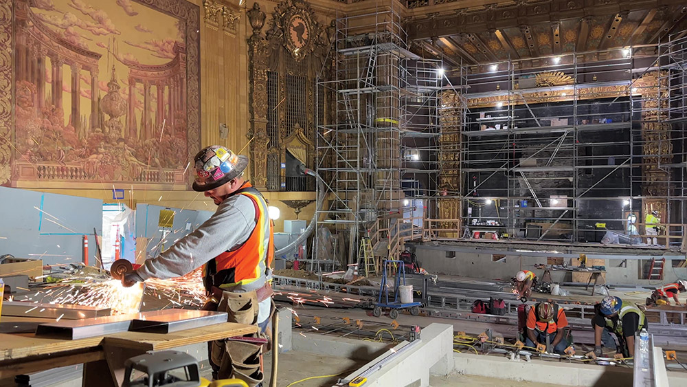 A sgraffito mural required little restoration, while the proscenium (right, scaffolded) that lay hidden behind a movie screen for many decades needed more than a month of cleaning and re-gilding work.