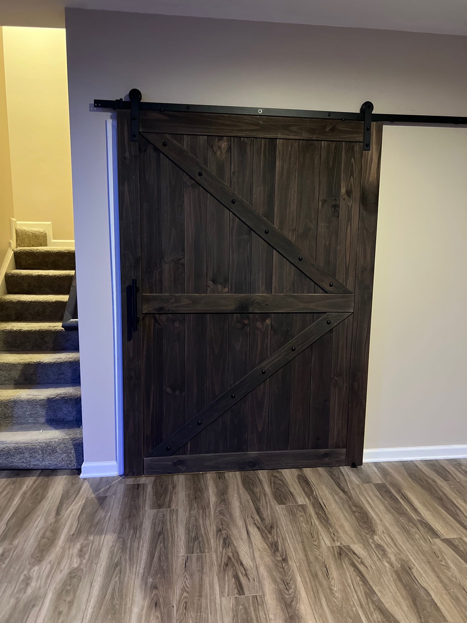 Installed a custom sliding barn door to separate the staircase from the finished basement area — blending functionality with rustic-modern style.