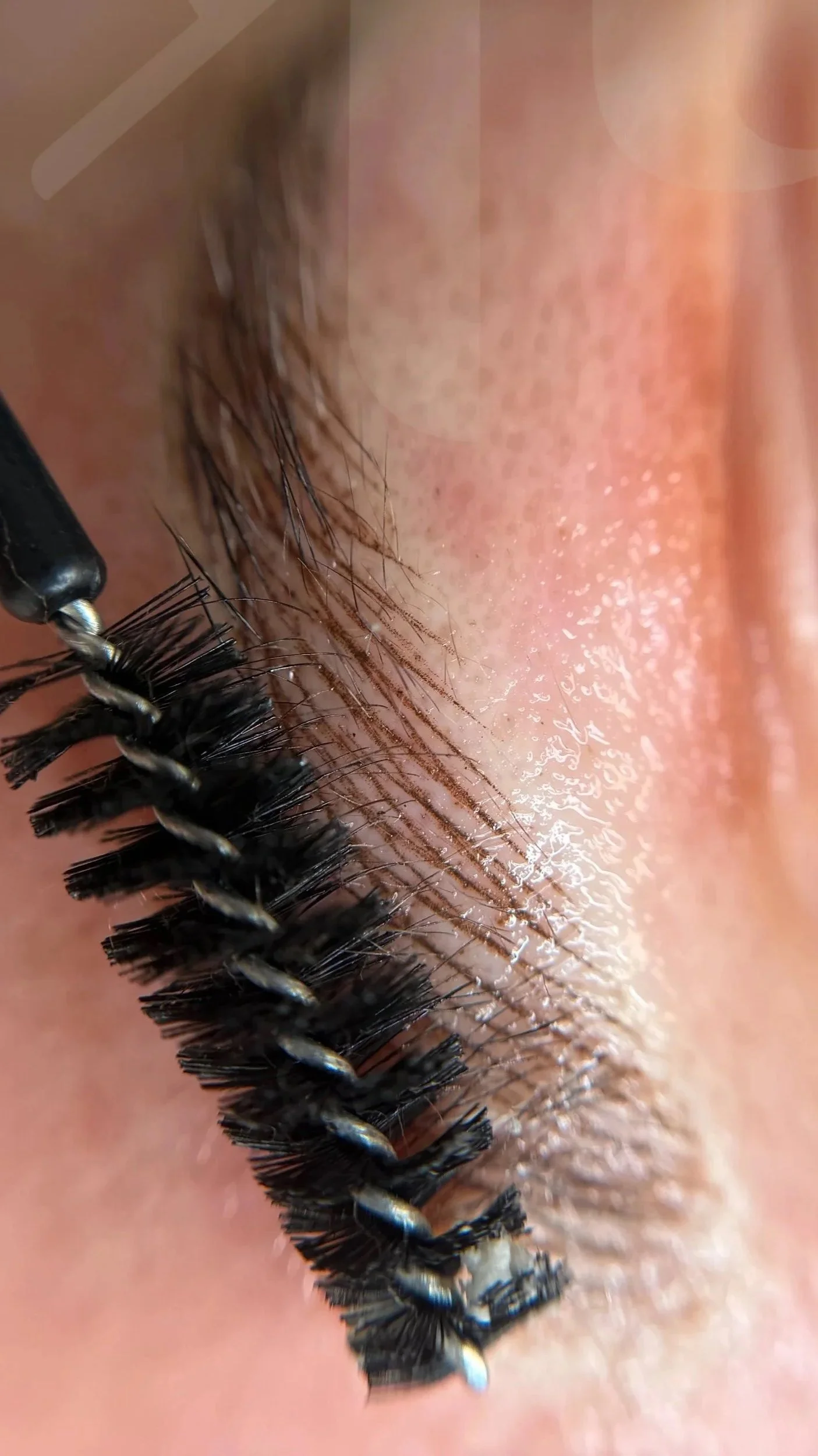 Close-up of eyelash extensions being applied to a person's eye lid.