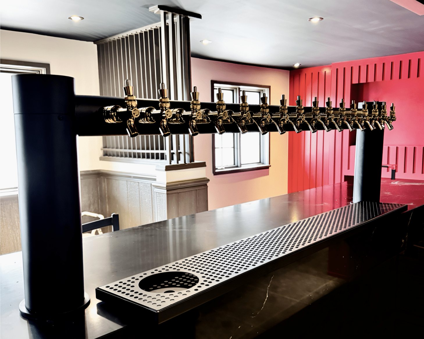 A row of beer taps on a bar counter in a modern interior space.