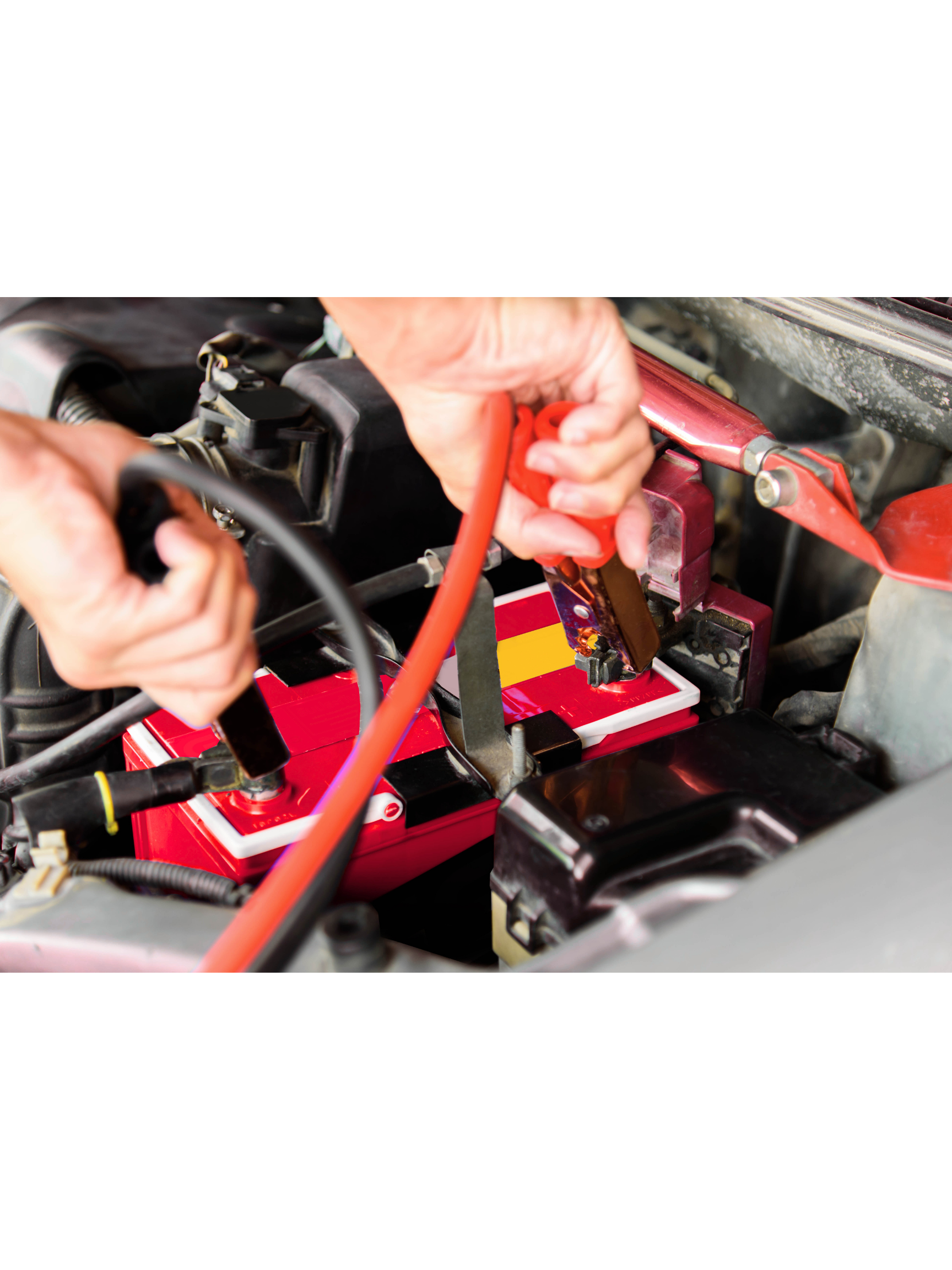 Person connecting a jump cable to a car battery under the hood.