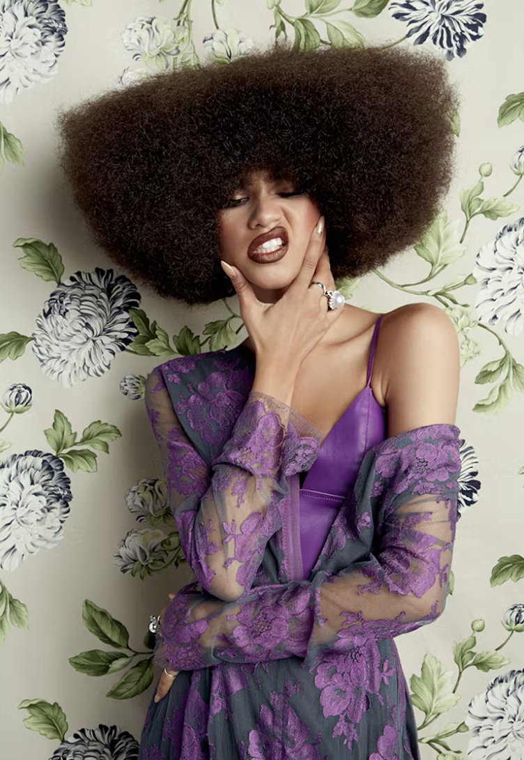 Zendaya in a purple leather top and lace jacket against a floral backdrop, from her 2015 Mane Addicts hair shoot. Hair by Larry Sims, styling by Law Roach, photography by Andrew Stiles, creative direction by Desirae Cherie of Templo Collective.